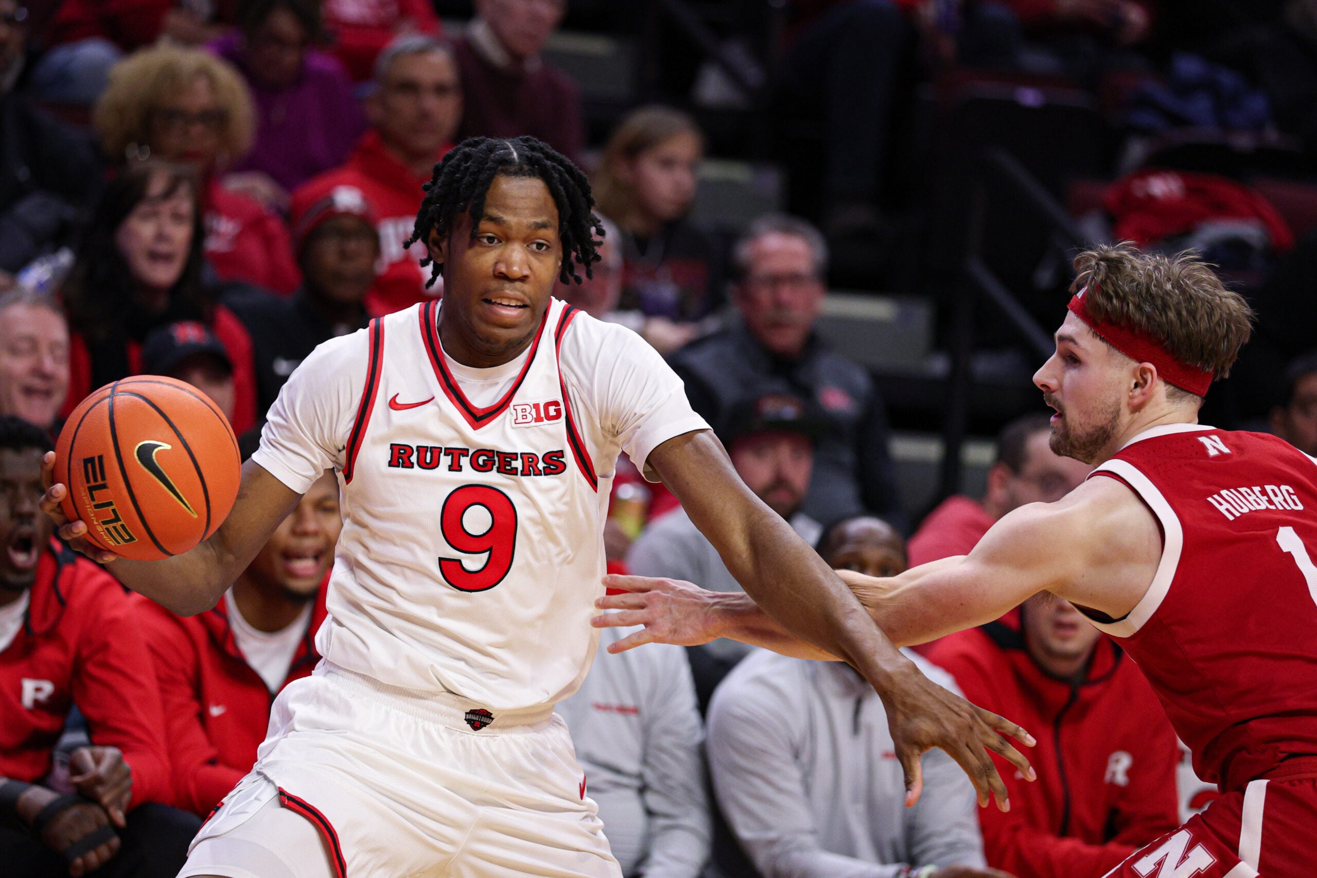 Feb 7, 2026; Piscataway, New Jersey, USA; Rutgers Scarlet Knights forward Dylan Grant (9) is guarded by Nebraska Cornhuskers guard Sam Hoiberg (1) during the second half at Jersey Mike's Arena. Mandatory Credit: Vincent Carchietta-Imagn Images