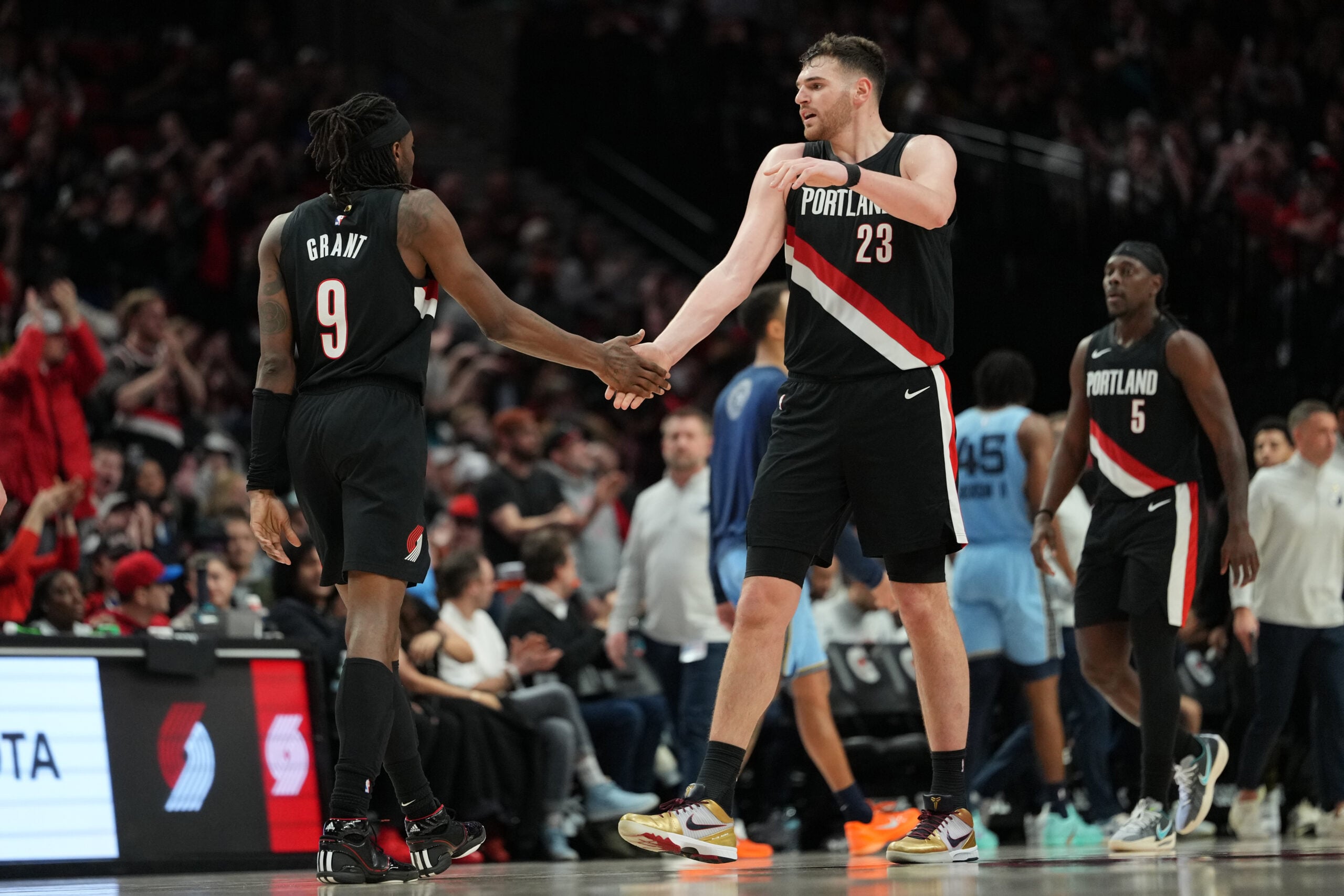 Feb 7, 2026; Portland, Oregon, USA; Portland Trail Blazers forward Jerami Grant (9) celebrates after making a three-point basket with teammate Donovan Clingan (23) during the second half against the Memphis Grizzlies at Moda Center. Mandatory Credit: Soobum Im-Imagn Images