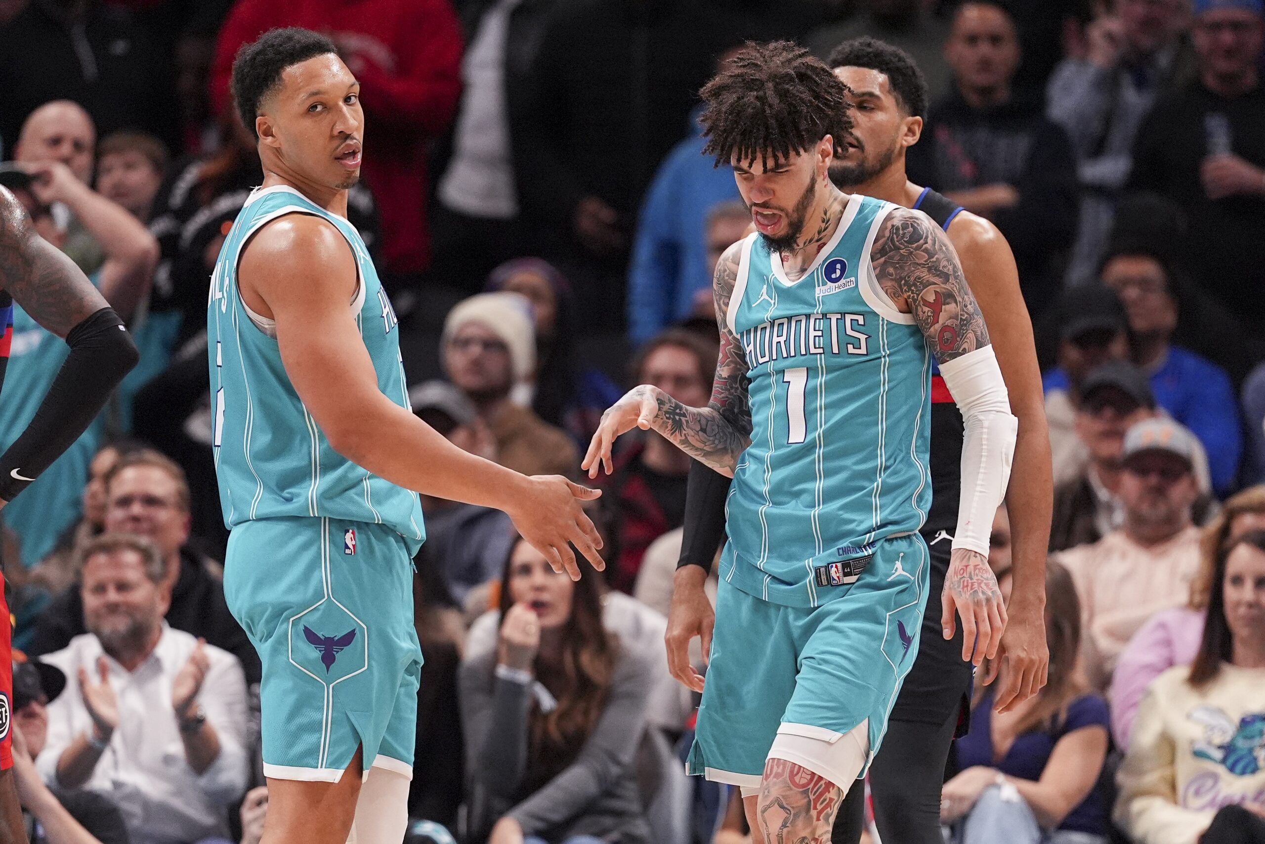 Feb 9, 2026; Charlotte, North Carolina, USA; Charlotte Hornets guard LaMelo Ball (1) and forward Grant Williams (2) after a thee point play against the Detroit Pistons during the second half at Spectrum Center. Mandatory Credit: Jim Dedmon-Imagn Images