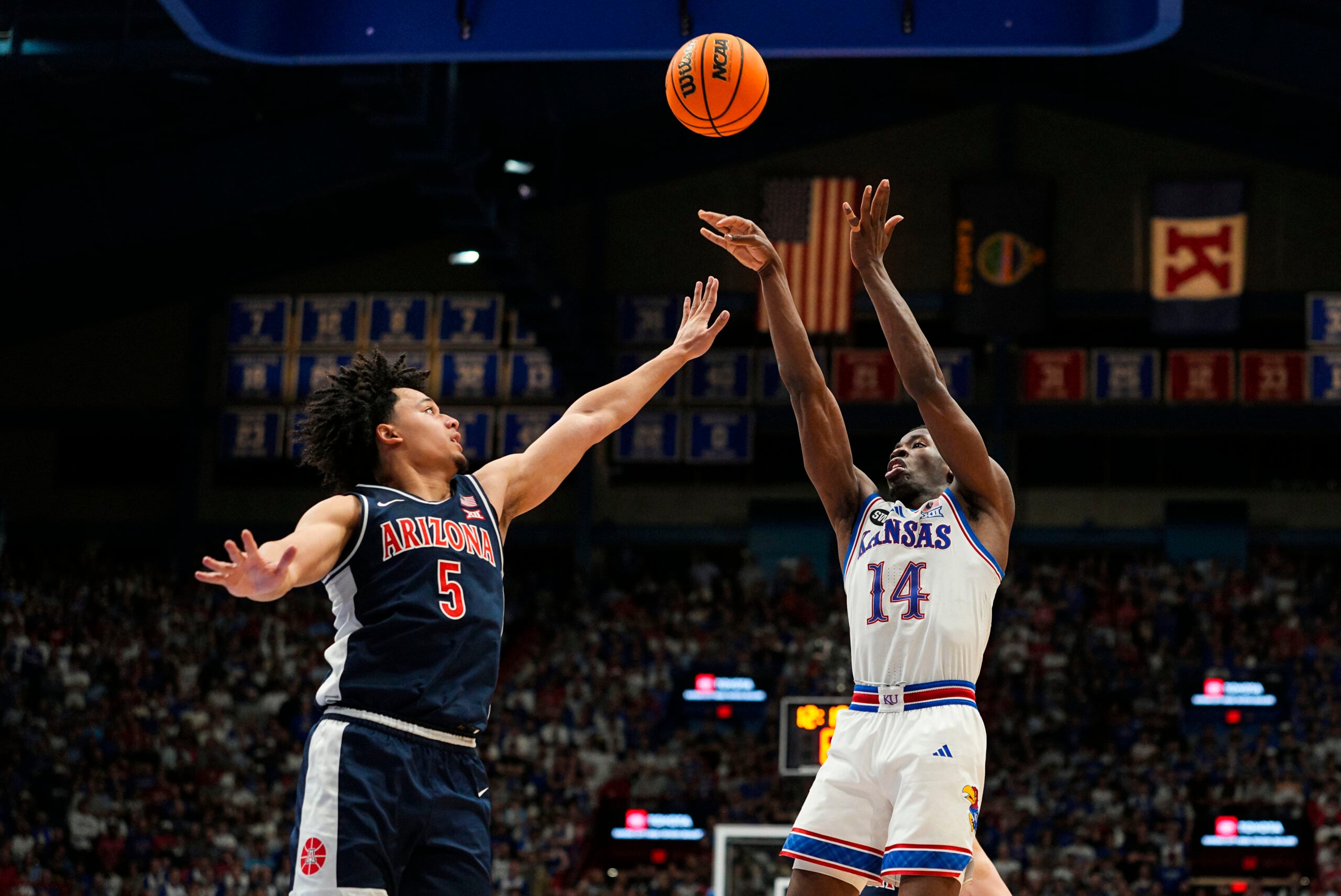 Feb 9, 2026; Lawrence, Kansas, USA; Kansas Jayhawks guard Melvin Council Jr. (14) shoots against Arizona Wildcats guard Brayden Burries (5) during the second half at Allen Fieldhouse. Mandatory Credit: Jay Biggerstaff-Imagn Images