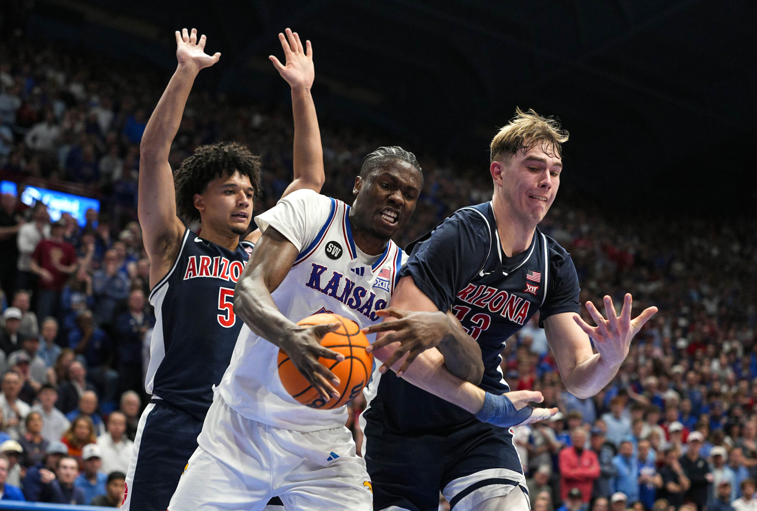 Feb 9, 2026; Lawrence, Kansas, USA; Kansas Jayhawks forward Flory Bidunga (40) and Arizona Wildcats center Motiejus Krivas (13) fight for a rebound during the second half at Allen Fieldhouse. Mandatory Credit: Jay Biggerstaff-Imagn Images