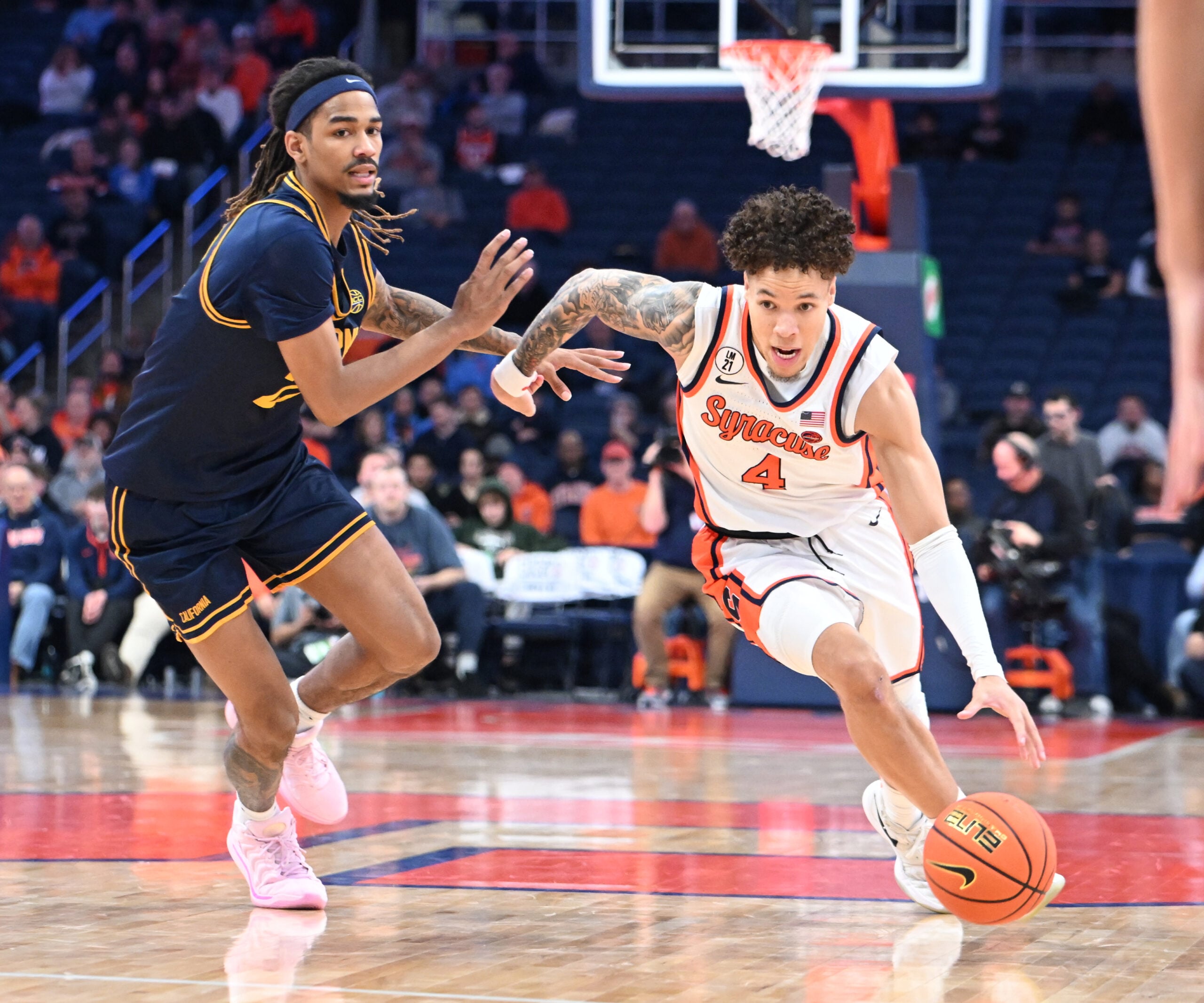 Feb 11, 2026; Syracuse, New York, USA; Syracuse Orange guard Nate Kingz (4) drives past California Golden Bears forward Chris Bell (22) in the second half at the JMA Wireless Dome. Mandatory Credit: Mark Konezny-Imagn Images