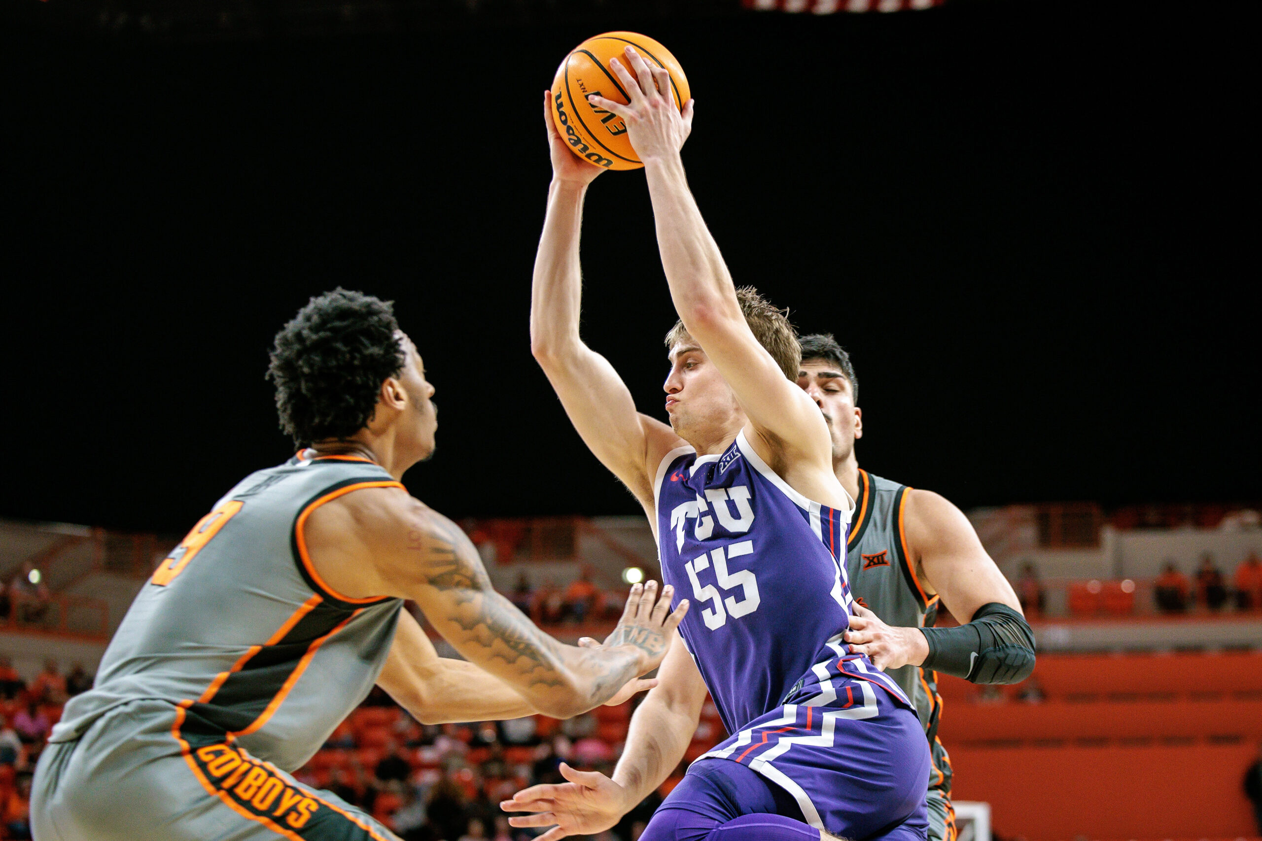 Feb 14, 2026; Stillwater, Oklahoma, USA; TCU Horned Frogs guard Tanner Toolson (55) drives to the basket around Oklahoma State Cowboys guard Anthony Roy (9) during the second half at Gallagher-Iba Arena. Mandatory Credit: William Purnell-Imagn Images