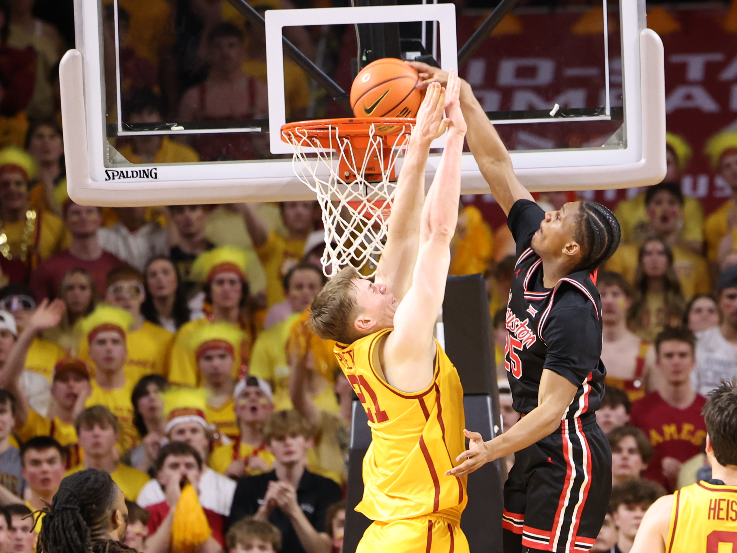 Feb 16, 2026; Ames, Iowa, USA; Houston Cougars guard Mercy Miller (25) dunks over Iowa State Cyclones forward Dominykas Pleta (21) during the first half at James H. Hilton Coliseum. Mandatory Credit: Reese Strickland-Imagn Images