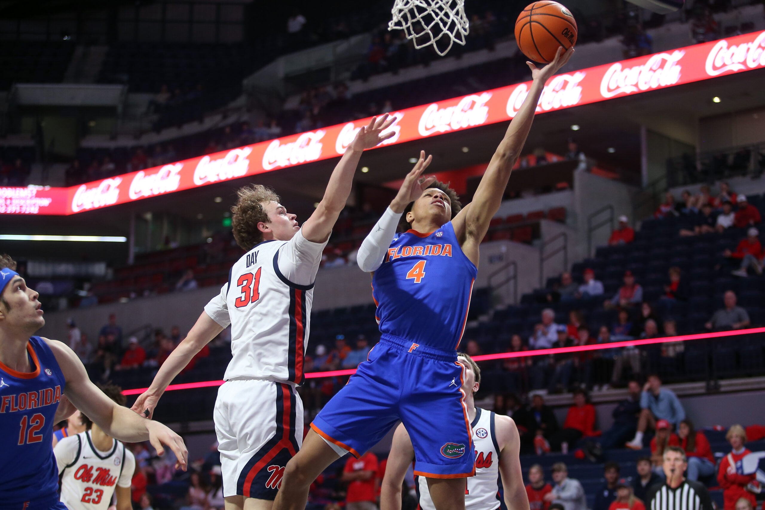 Feb 21, 2026; Oxford, Mississippi, USA; Florida Gators guard Alex Lloyd (4) shoots as Mississippi Rebels guard Zach Day (31) defends during the second half at The Sandy and John Black Pavilion at Ole Miss. Mandatory Credit: Petre Thomas-Imagn Images