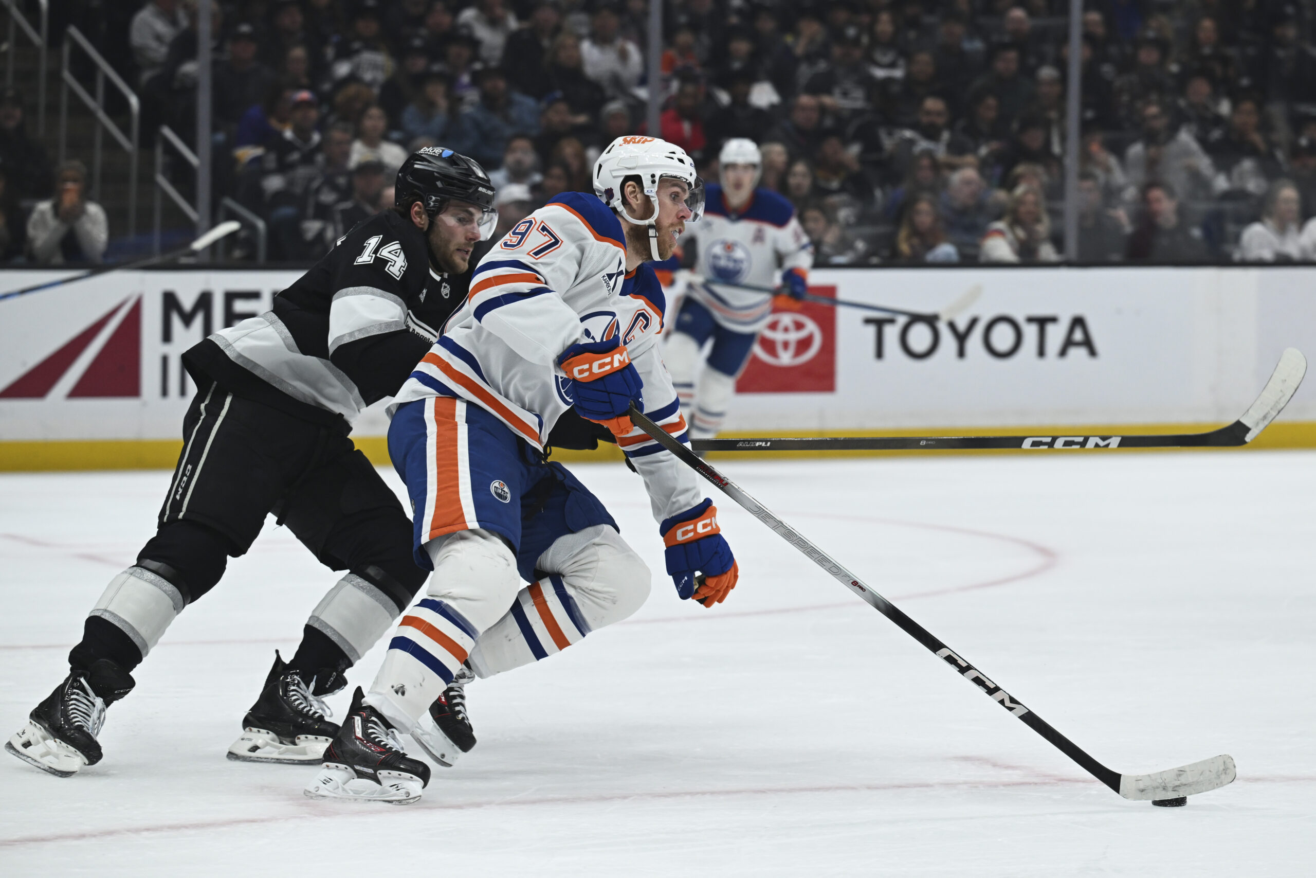 Feb 26, 2026; Los Angeles, California, USA; Edmonton Oilers center Connor McDavid (97) and Los Angeles Kings right wing Alex Laferriere (14) battle for the puck during the second period at Crypto.com Arena. Mandatory Credit: Griffin Hooper-Imagn Images