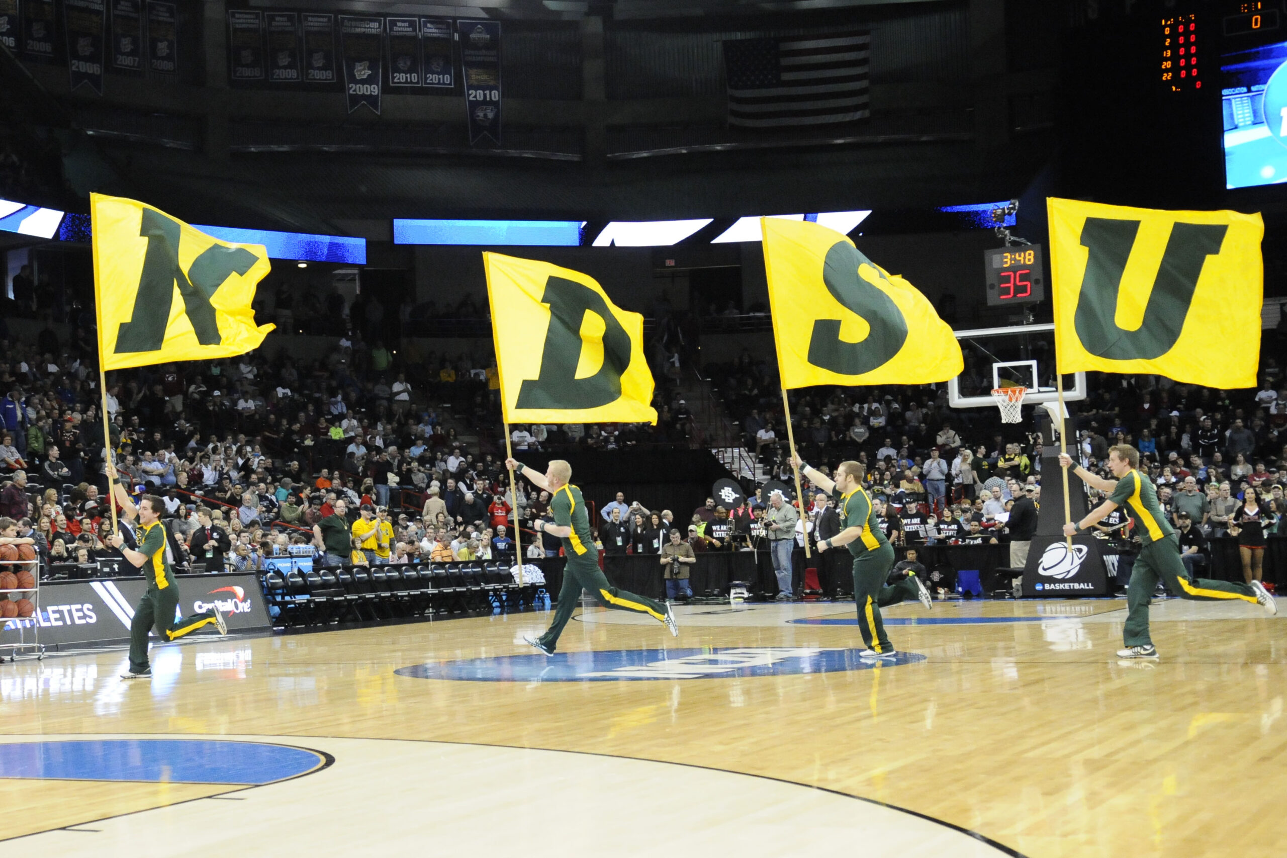 Mar 22, 2014; Spokane, WA, USA; North Dakota State Bison cheerleaders run across court with flags before a men's college basketball game during the third round of the 2014 NCAA Tournament against the San Diego State Aztecs at Veterans Memorial Arena. Mandatory Credit: James Snook-Imagn Images