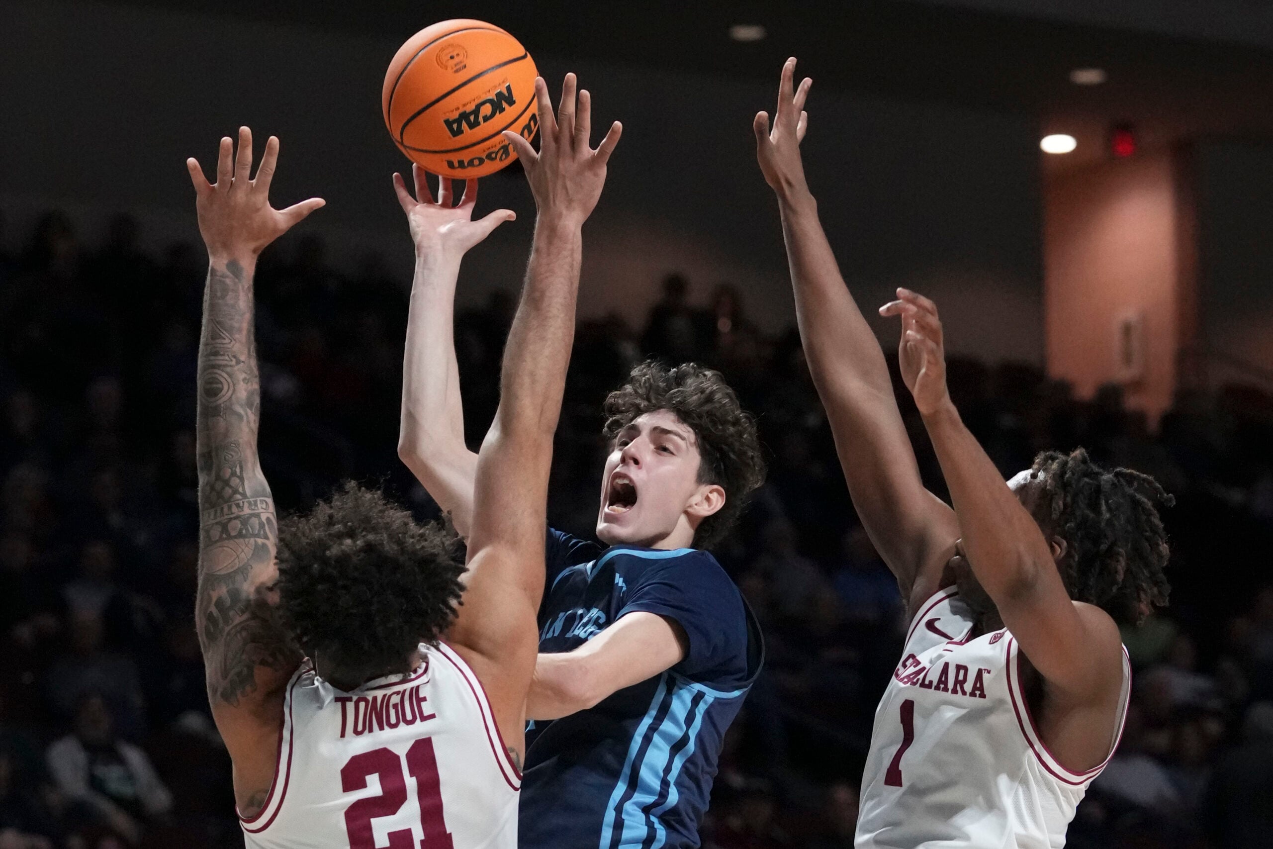 March 9, 2024; Las Vegas, NV, USA; San Diego Toreros guard Dragos Lungu (7) shoots the basketball against Santa Clara Broncos forward Camaron Tongue (21) and guard Tyeree Bryan (1) during the first half in the quarterfinals of the WCC Basketball Championship at Orleans Arena. Mandatory Credit: Kyle Terada-Imagn Images