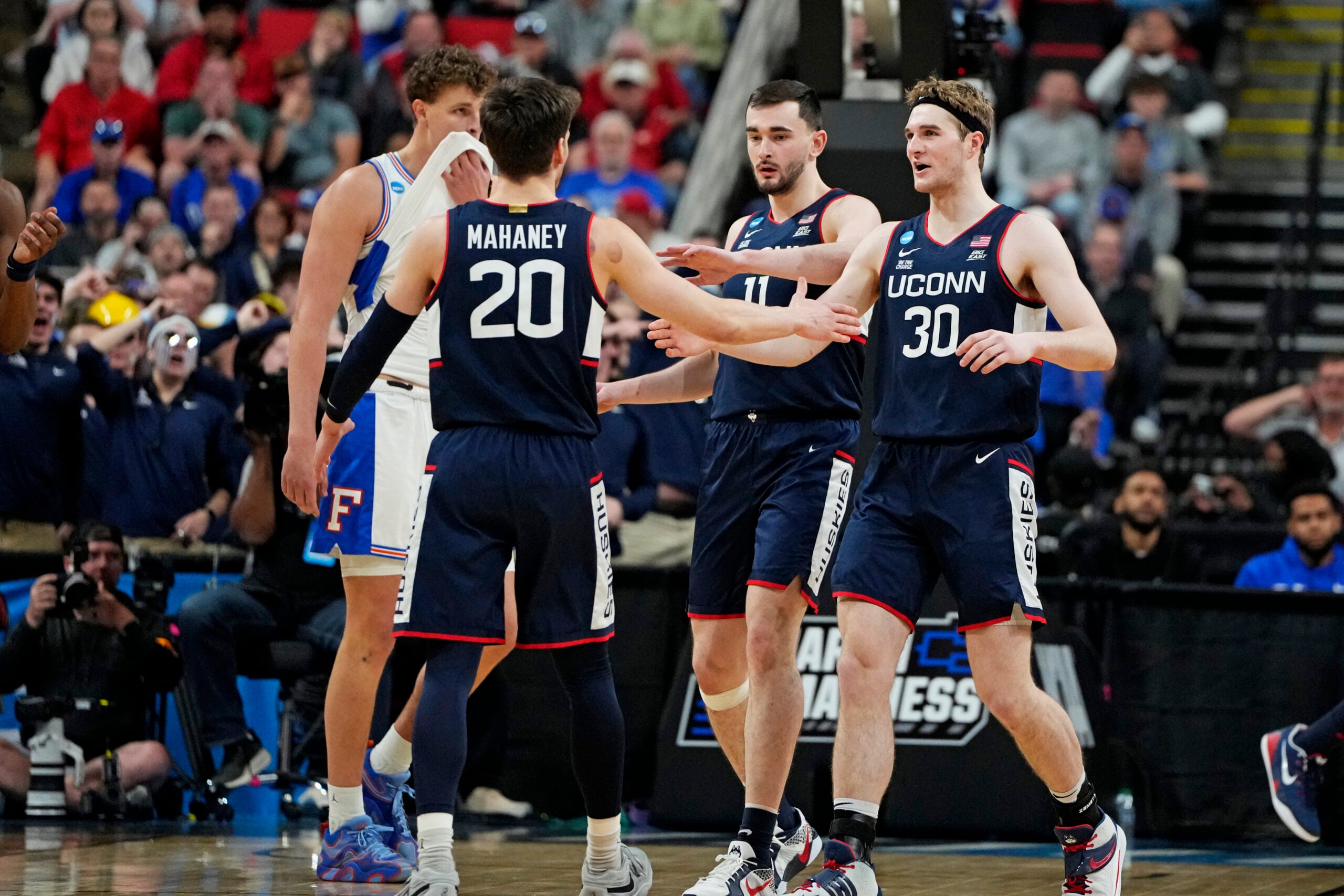 Mar 23, 2025; Raleigh, NC, USA; Connecticut Huskies guard Aidan Mahaney (20) and Connecticut Huskies forward Liam McNeeley (30) react after a play during the second half against the Florida Gators in the second round of the NCAA Tournament at Lenovo Center. Mandatory Credit: Bob Donnan-Imagn Images