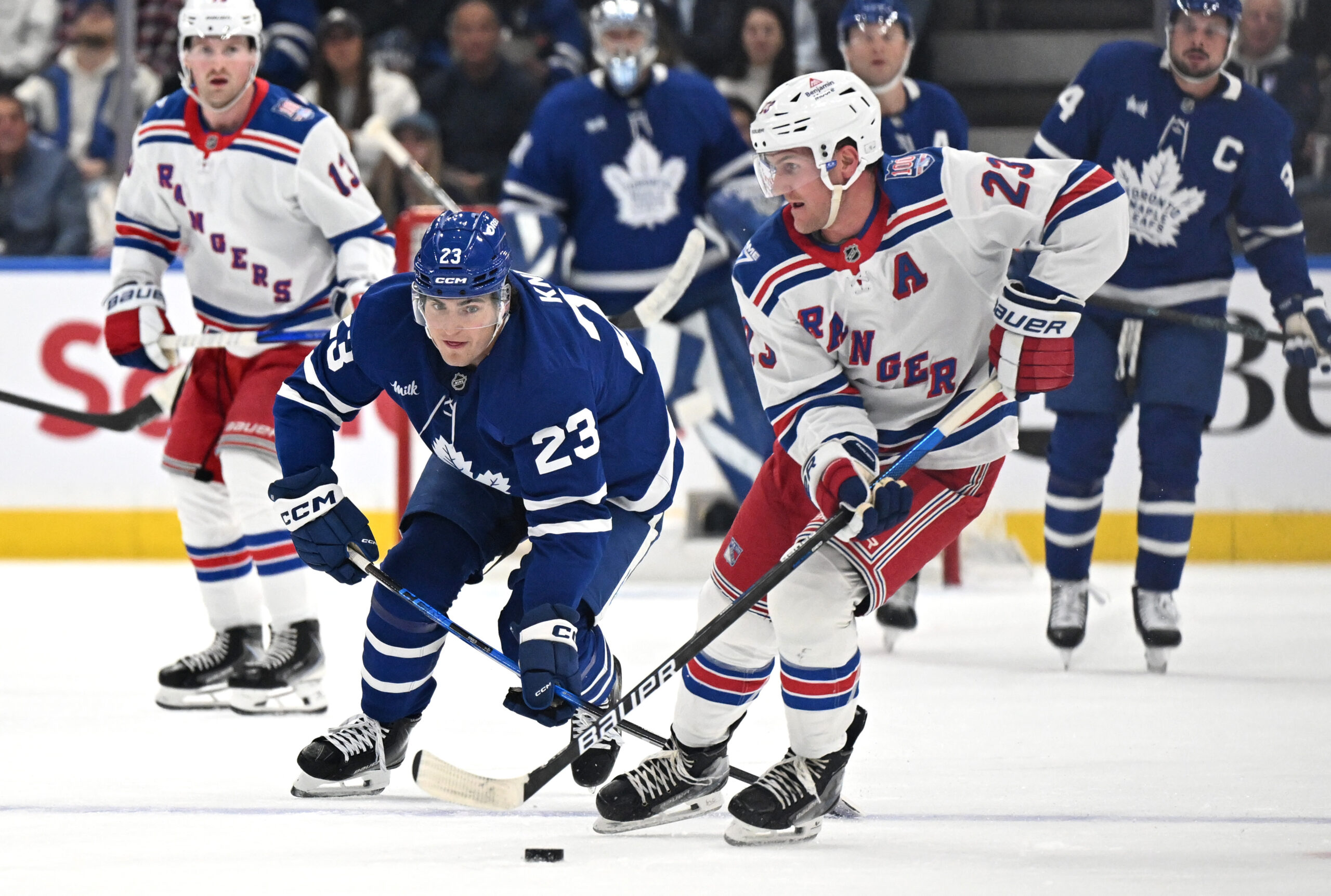 Oct 16, 2025; Toronto, Ontario, CAN; New York Rangers defenseman Adam Fox (23) moves the puck away from Toronto Maple Leafs forward Matthews Knies (23) in the first period at Scotiabank Arena. Mandatory Credit: Dan Hamilton-Imagn Images