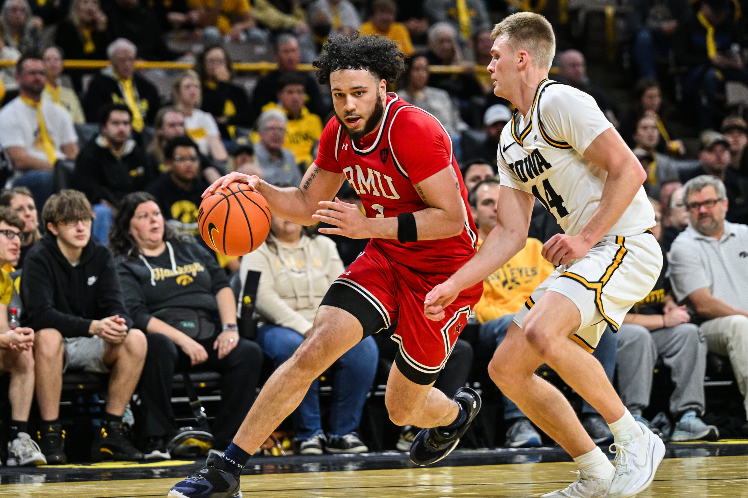 Nov 4, 2025; Iowa City, Iowa, USA; Robert Morris Colonials guard Ryan Prather Jr. (2) goes to the basket as Iowa Hawkeyes guard Bennett Stirtz (14) defends during the first half at Carver-Hawkeye Arena. Mandatory Credit: Jeffrey Becker-Imagn Images