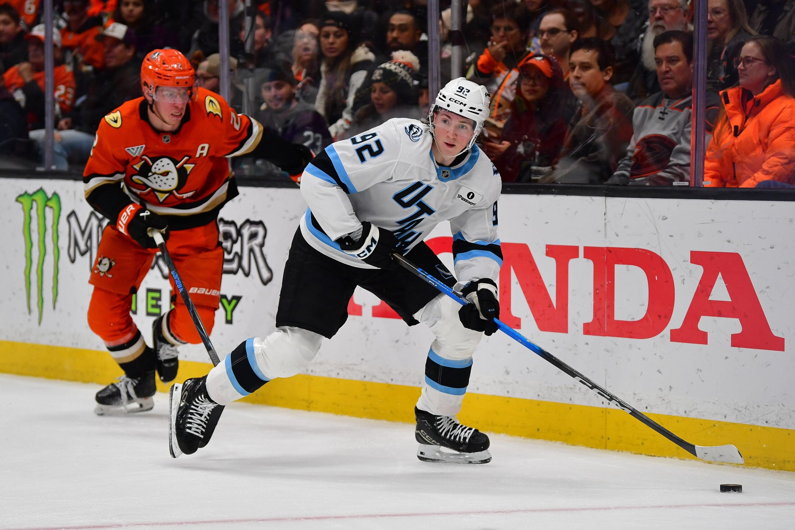 Dec 3, 2025; Anaheim, California, USA; Utah Mammoth center Logan Cooley (92) moves the puck ahead of Anaheim Ducks defenseman Jackson Lacombe (2) during the second period at Honda Center. Mandatory Credit: Gary A. Vasquez-Imagn Images