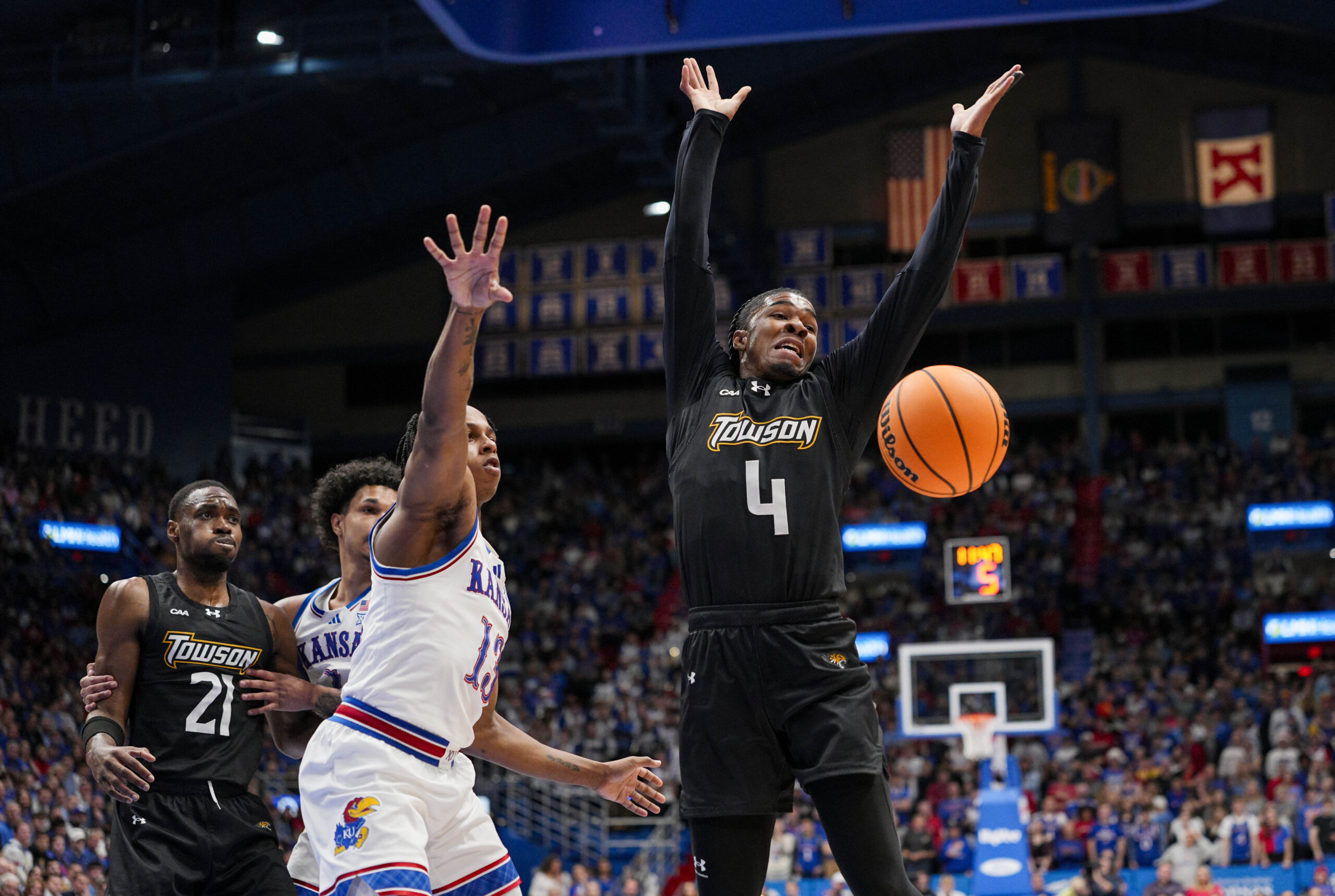 Dec 16, 2025; Lawrence, Kansas, USA; Kansas Jayhawks guard Elmarko Jackson (13) knocks the ball away from Towson Tigers guard Dylan Williamson (4) during the first half at Allen Fieldhouse. Mandatory Credit: Jay Biggerstaff-Imagn Images