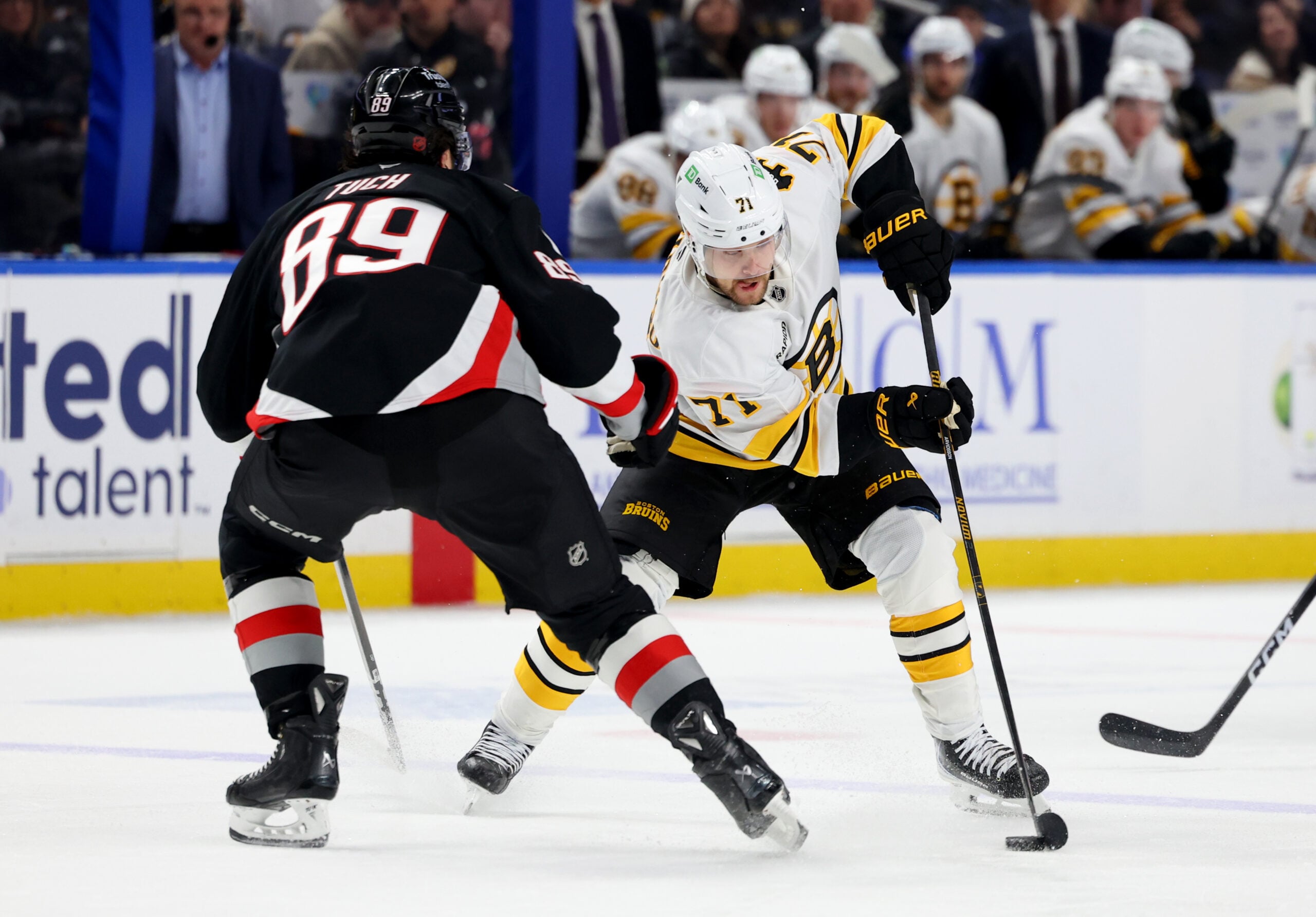 Dec 27, 2025; Buffalo, New York, USA;  Boston Bruins left wing Viktor Arvidsson (71) skates with the puck as Buffalo Sabres right wing Alex Tuch (89) defends during the third period at KeyBank Center. Mandatory Credit: Timothy T. Ludwig-Imagn Images