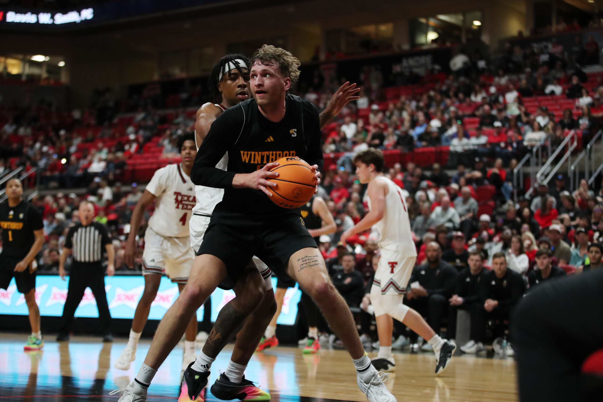 Dec 28, 2025; Lubbock, Texas, USA;  Winthrop Eagles center Logan Duncomb (51) holds the ball against Texas Tech Red Raiders forward JT Toppin (15) in the second half at United Supermarkets Arena. Mandatory Credit: Michael C. Johnson-Imagn Images
