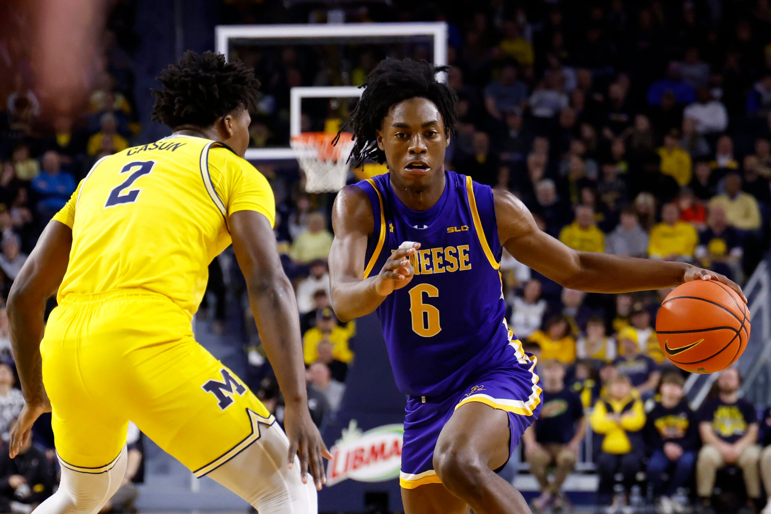 Dec 29, 2025; Ann Arbor, Michigan, USA;  McNeese Cowboys guard Larry Johnson (6) dribbles defended by Michigan Wolverines guard L.J. Cason (2) in the second half at Crisler Center. Mandatory Credit: Rick Osentoski-Imagn Images