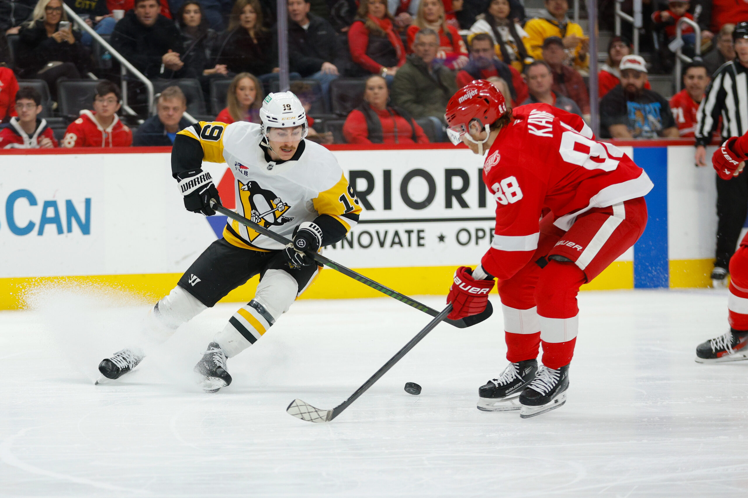 Jan 3, 2026; Detroit, Michigan, USA; Pittsburgh Penguins center Connor Dewar (19) handles the puck against Detroit Red Wings right wing Patrick Kane (88) during the first period at Little Caesars Arena. Mandatory Credit: Brian Bradshaw Sevald-Imagn Images