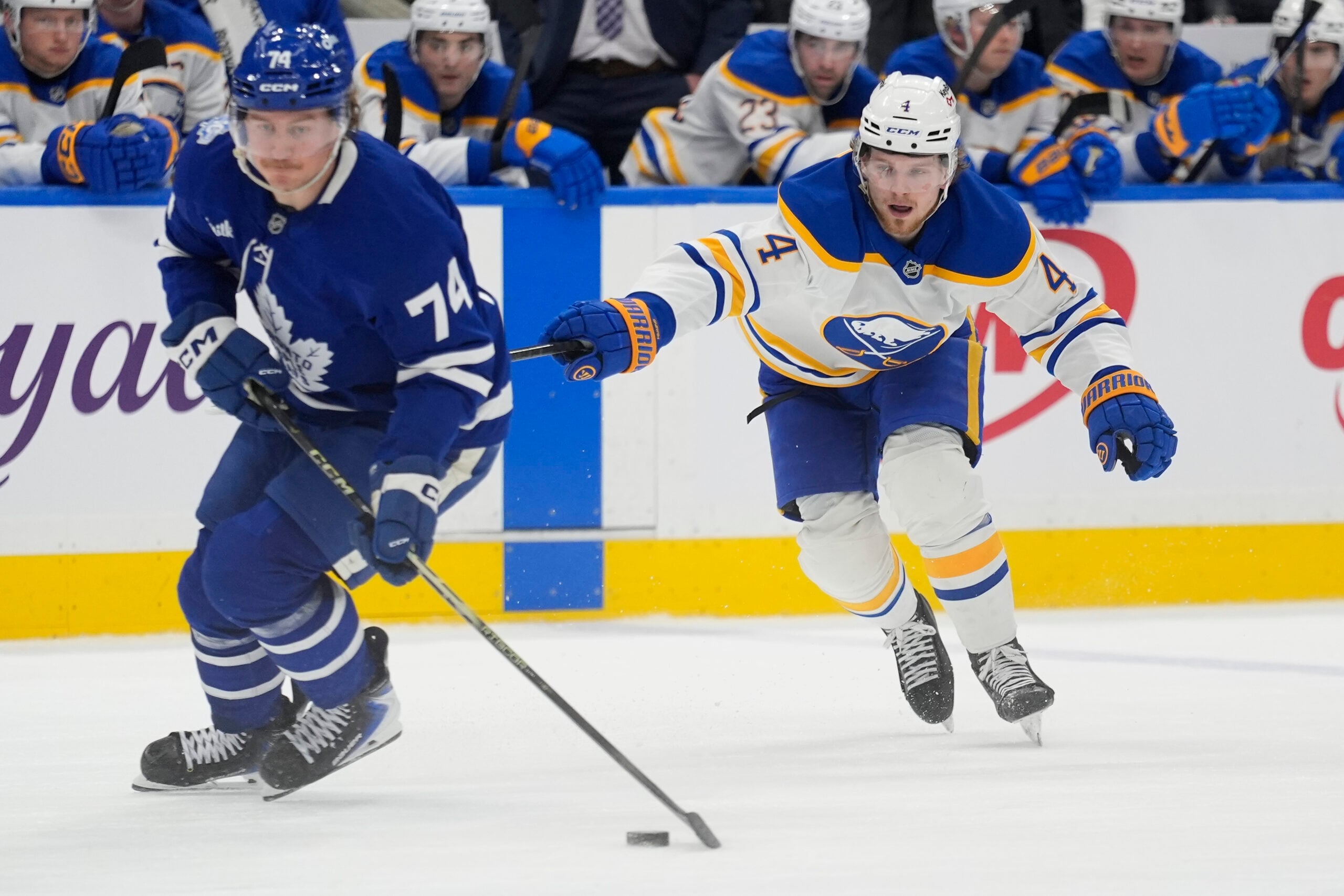 Jan 27, 2026; Toronto, Ontario, CAN; Buffalo Sabres defenseman Bowen Byram (4) tries to slow down Toronto Maple Leafs forward Bobby McMann (74) during the third period at Scotiabank Arena. Mandatory Credit: John E. Sokolowski-Imagn Images