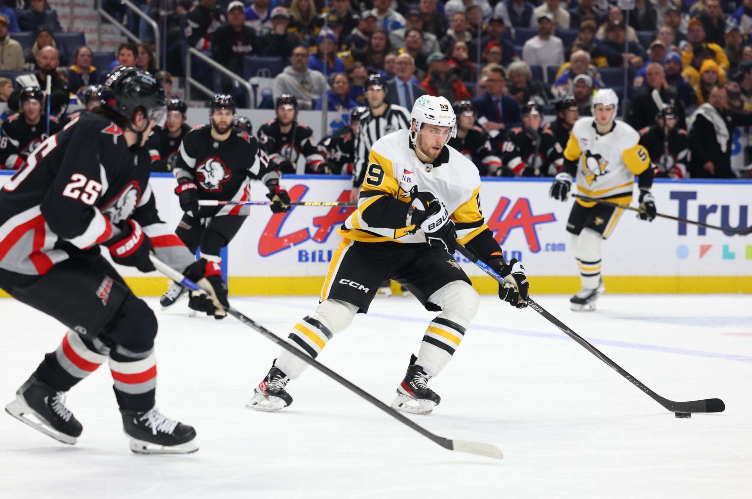 Feb 5, 2026; Buffalo, New York, USA;  Pittsburgh Penguins right wing Egor Chinakhov (59) carries the puck as Buffalo Sabres defenseman Owen Power (25) defends during the third period at KeyBank Center. Mandatory Credit: Timothy T. Ludwig-Imagn Images