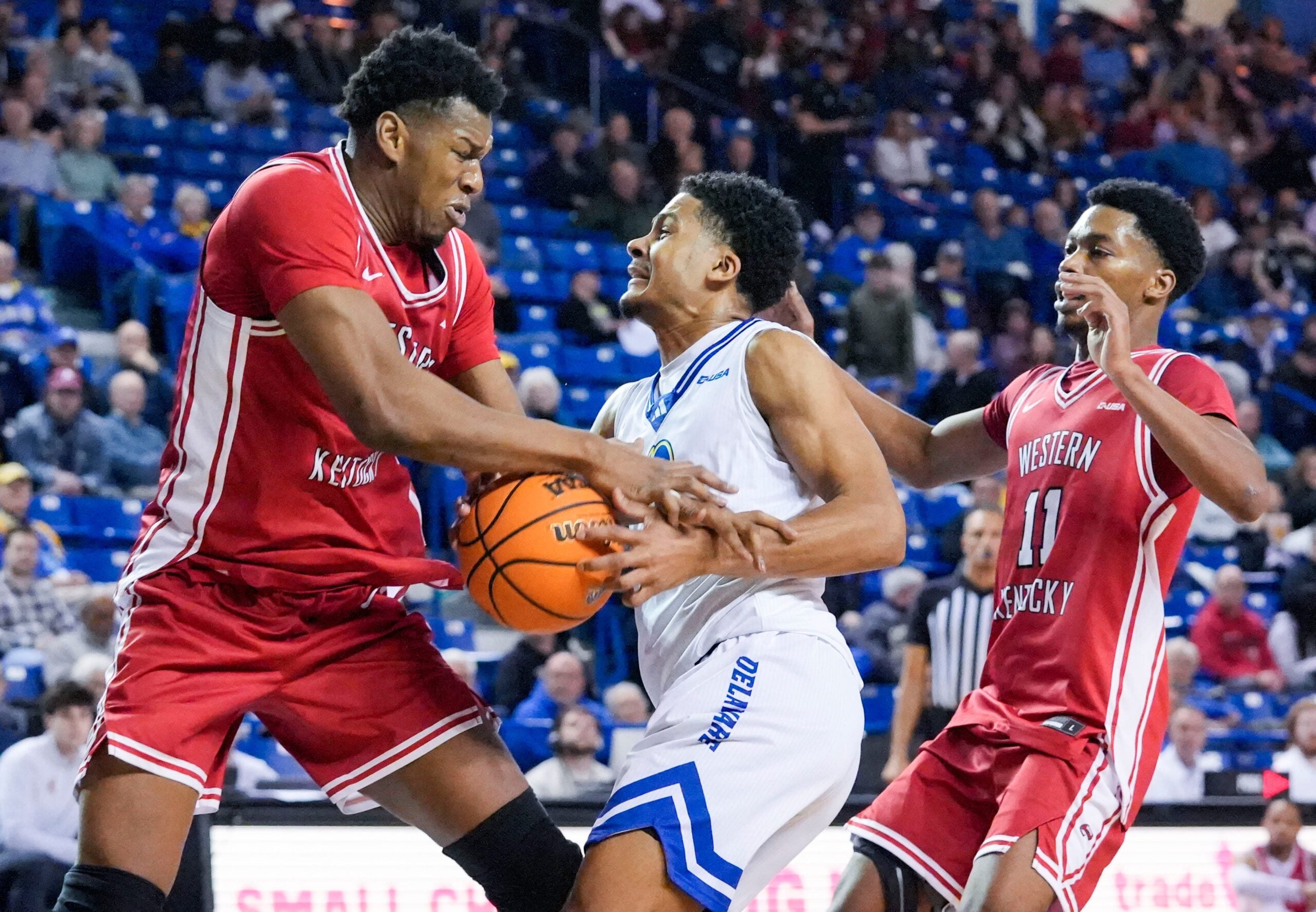 Delaware’s Justyn Fernandez moves between Western Kentucky’s Blaise Keita (left) and Terrion Murdix in the first half of Western Kentucky’s 88-87 overtime win at the Bob Carpenter Center, Feb. 18, 2026.