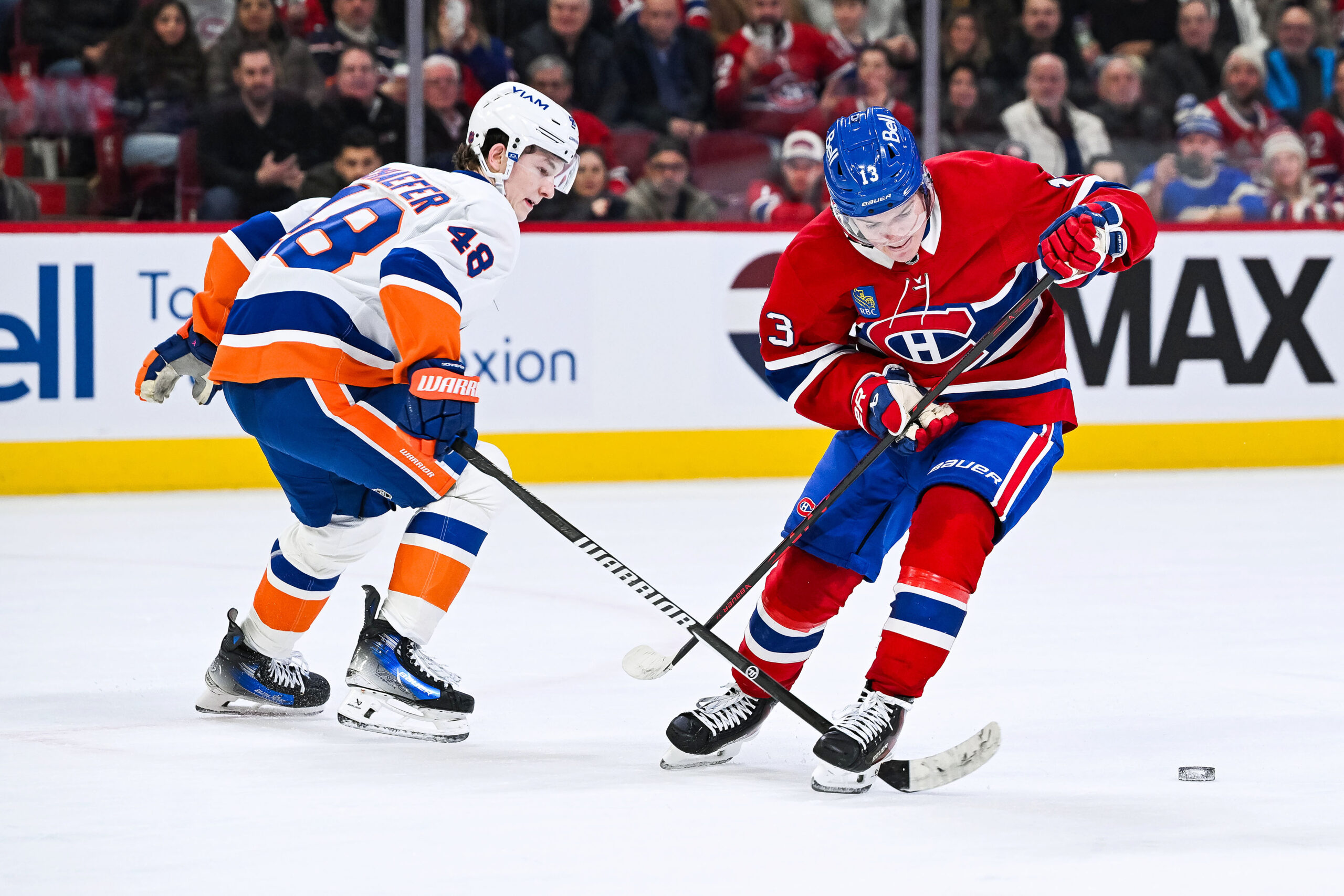Feb 26, 2026; Montreal, Quebec, CAN; New York Islanders defenseman Matthew Schaefer (48) defends the puck against Montreal Canadiens right wing Cole Caufield (13) during overtime at Bell Centre. Mandatory Credit: David Kirouac-Imagn Images