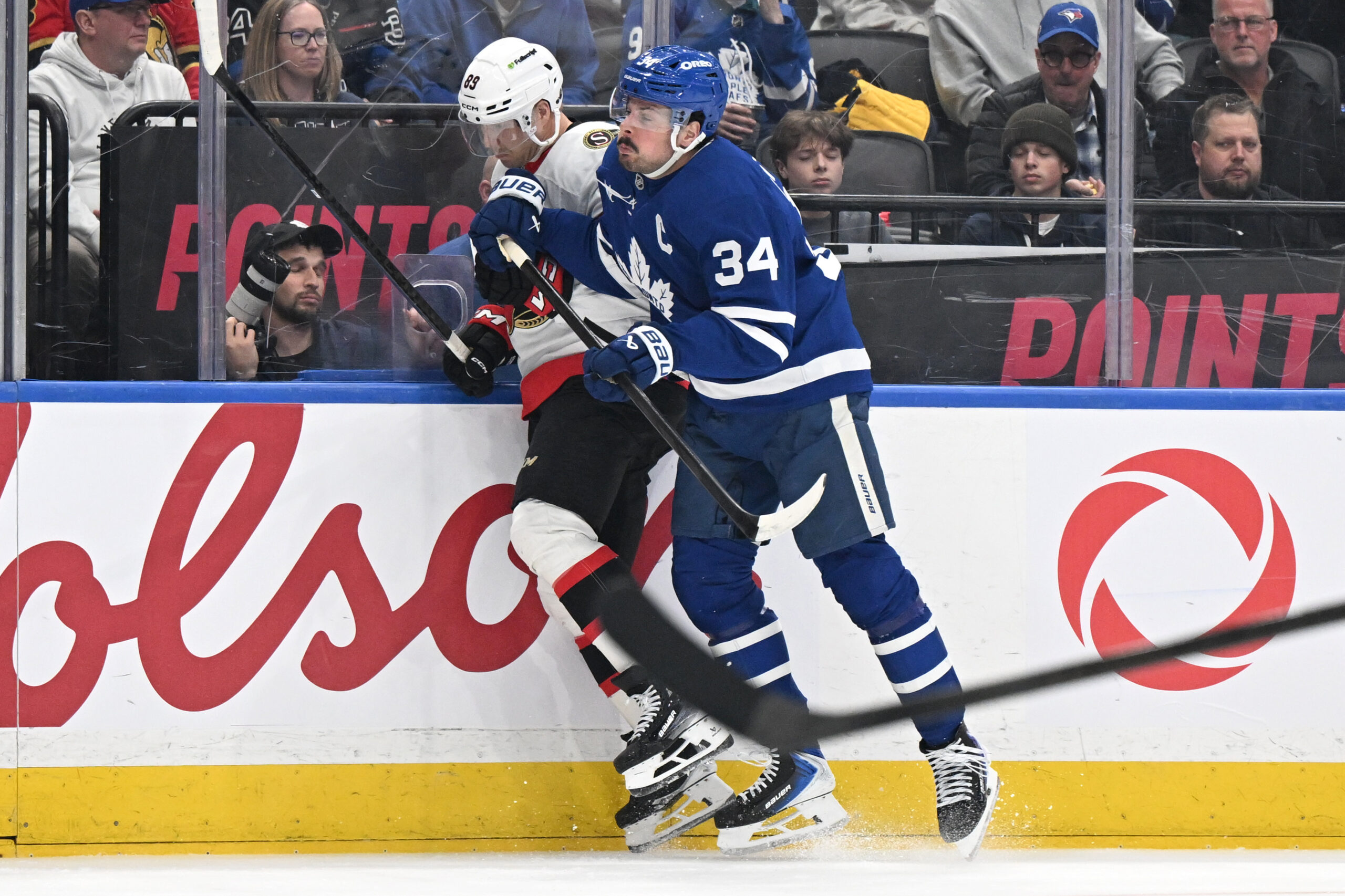 Feb 28, 2026; Toronto, Ontario, CAN; Toronto Maple Leafs forward Auston Matthews (34) bodychecks Ottawa Senators forward Lars Eller (89) in the third period at Scotiabank Arena. Mandatory Credit: Dan Hamilton-Imagn Images
