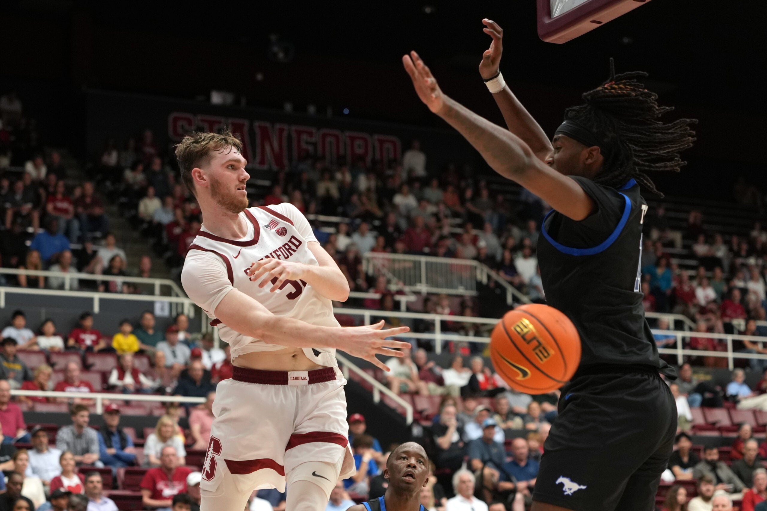 Feb 28, 2026; Stanford, California, USA; Stanford Cardinal forward Aidan Cammann (left) passes against Southern Methodist University Mustangs center Jaden Toombs (right) during the second half at Maples Pavilion. Mandatory Credit: Darren Yamashita-Imagn Images