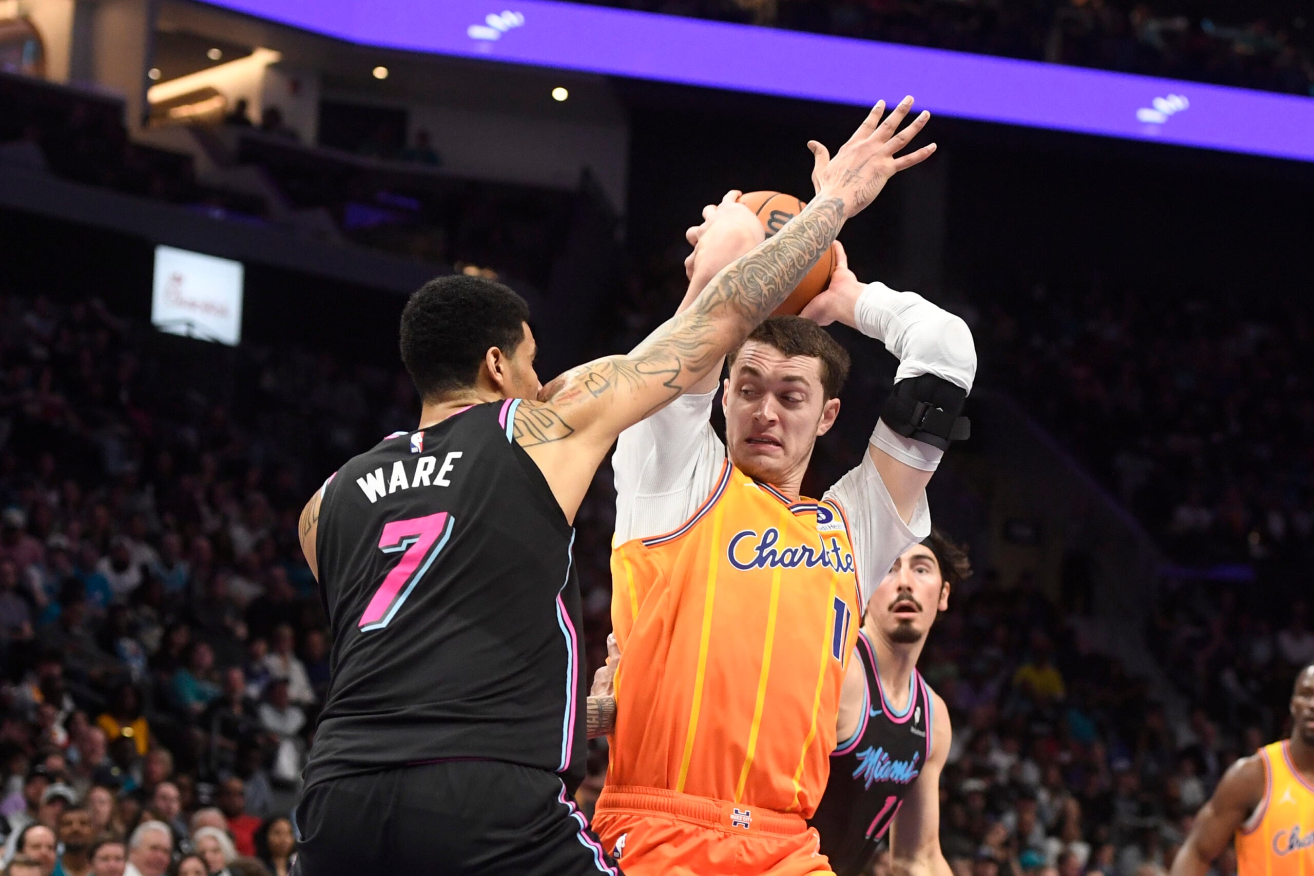 Mar 6, 2026; Charlotte, North Carolina, USA;  Charlotte Hornets center Ryan Kalkbrenner (11) looks to pass as he is defended by Miami Heat center Kel’el Ware (7) during the second half at the Spectrum Center. Mandatory Credit: Sam Sharpe-Imagn Images