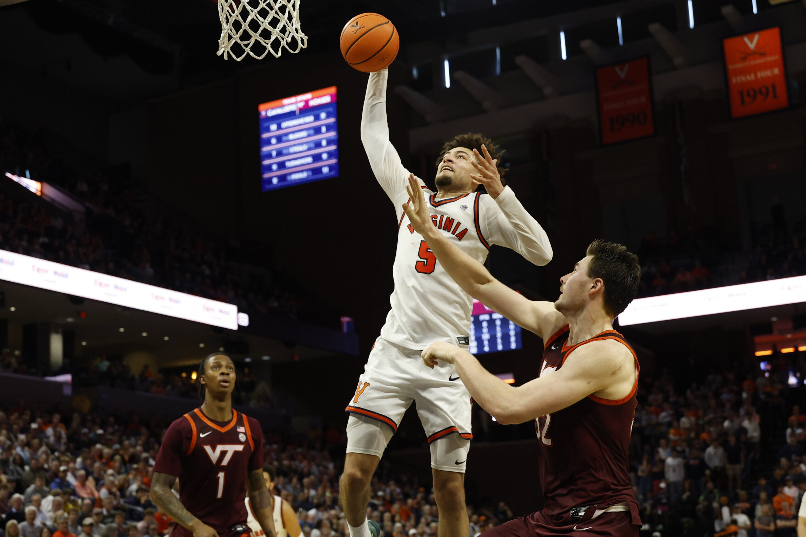 Mar 7, 2026; Charlottesville, Virginia, USA; Virginia Cavaliers guard Sam Lewis (5) attempts a dunks as Virginia Tech Hokies center Christian Gurdak (32) defends in the second half at John Paul Jones Arena. Mandatory Credit: Geoff Burke-Imagn Images