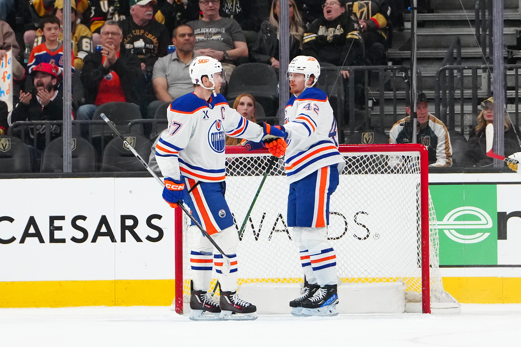 Mar 8, 2026; Las Vegas, Nevada, USA; Edmonton Oilers right wing Kasperi Kapanen (42) celebrates with center Connor McDavid (97) after scoring an empty net goal against the Vegas Golden Knights during the third period at T-Mobile Arena. Mandatory Credit: Stephen R. Sylvanie-Imagn Images