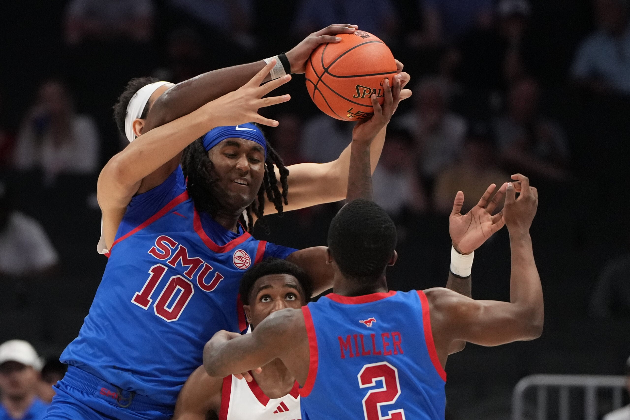 Mar 11, 2026; Charlotte, NC, USA; Southern Methodist University Mustangs center Jaden Toombs (10) passes to guard Boopie Miller (2) as Louisville Cardinals center Aly Khalifa (15) and guard Kobe Rodgers (11) defend in the second half at Spectrum Center. Mandatory Credit: Bob Donnan-Imagn Images
