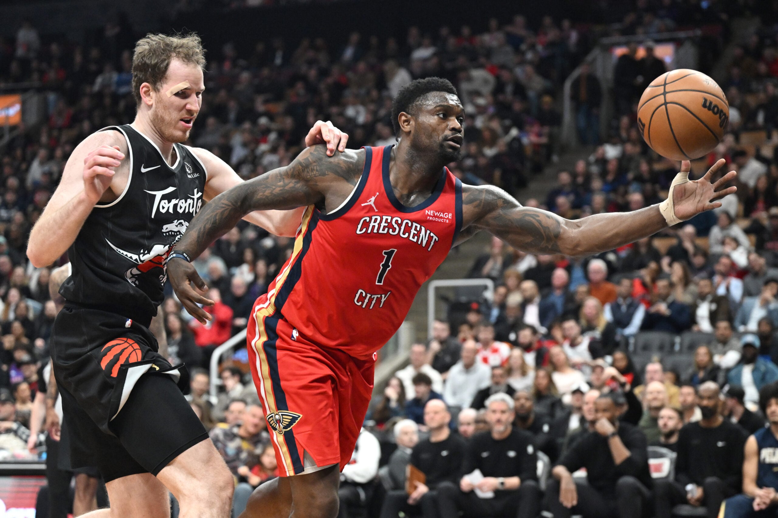 Mar 27, 2026; Toronto, Ontario, CAN;  New Orleans Pelicans forward Zion Williamson (1) reaches for a loose ball ahead of Toronto Raptors center Jakob Poeltl (19) in the first half at Scotiabank Arena. Mandatory Credit: Dan Hamilton-Imagn Images