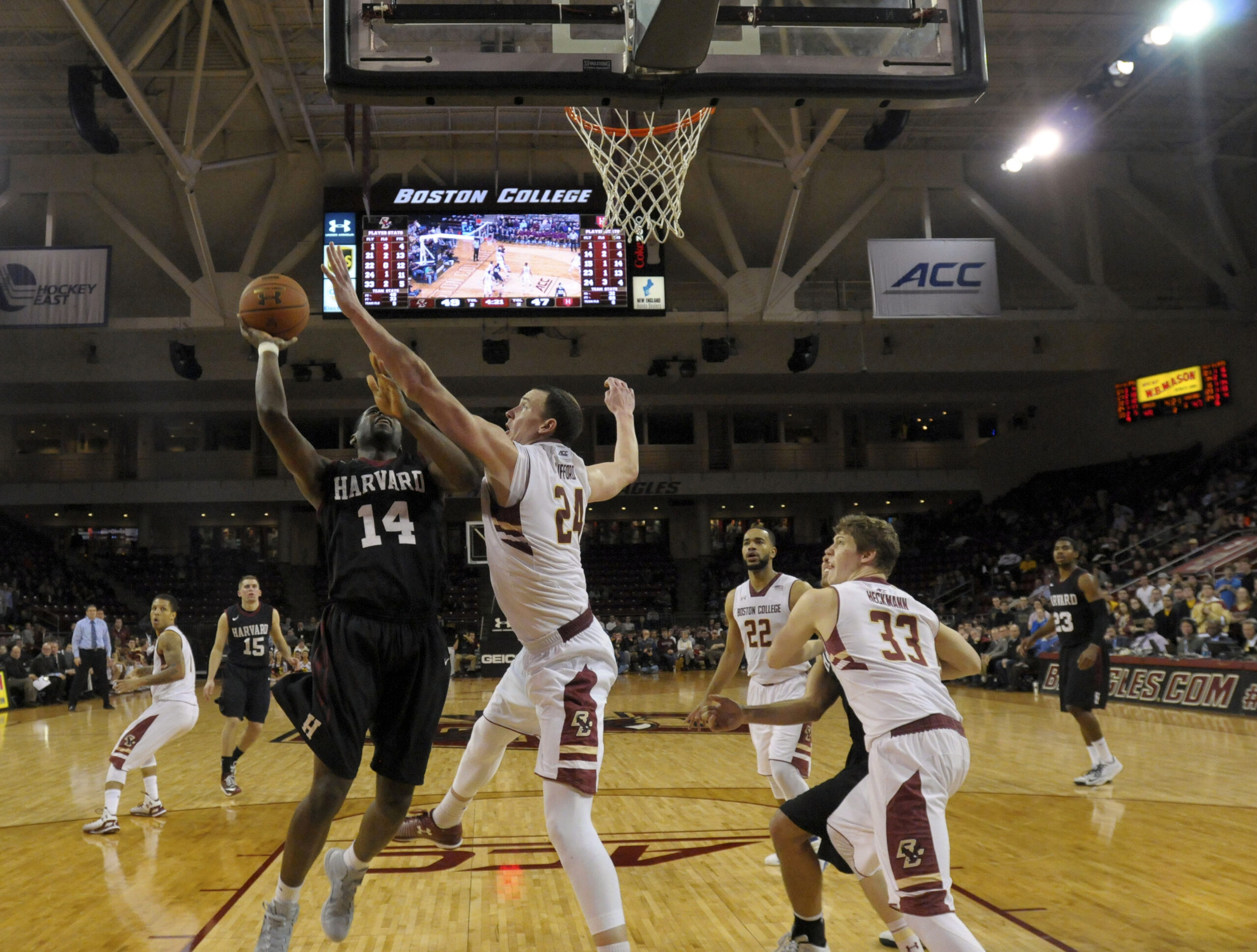 Jan 14, 2015; Chestnut Hill, MA, USA; Harvard Crimson forward Steve Moundou-Missi (14) is fouled by Boston College Eagles center Dennis Clifford (24) during overtime at Silvio O. Conte Forum. Mandatory Credit: Bob DeChiara-Imagn Images
