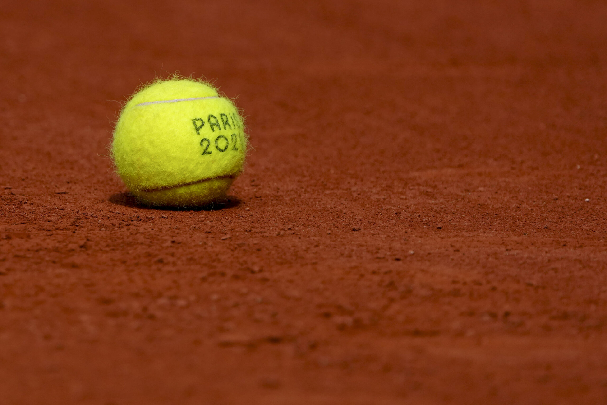Jul 31, 2024; Paris, France; A tennis ball sits on the clay courts during the Paris 2024 Olympic Summer Games at Stade Roland Garros. Mandatory Credit: Kirby Lee-Imagn Images