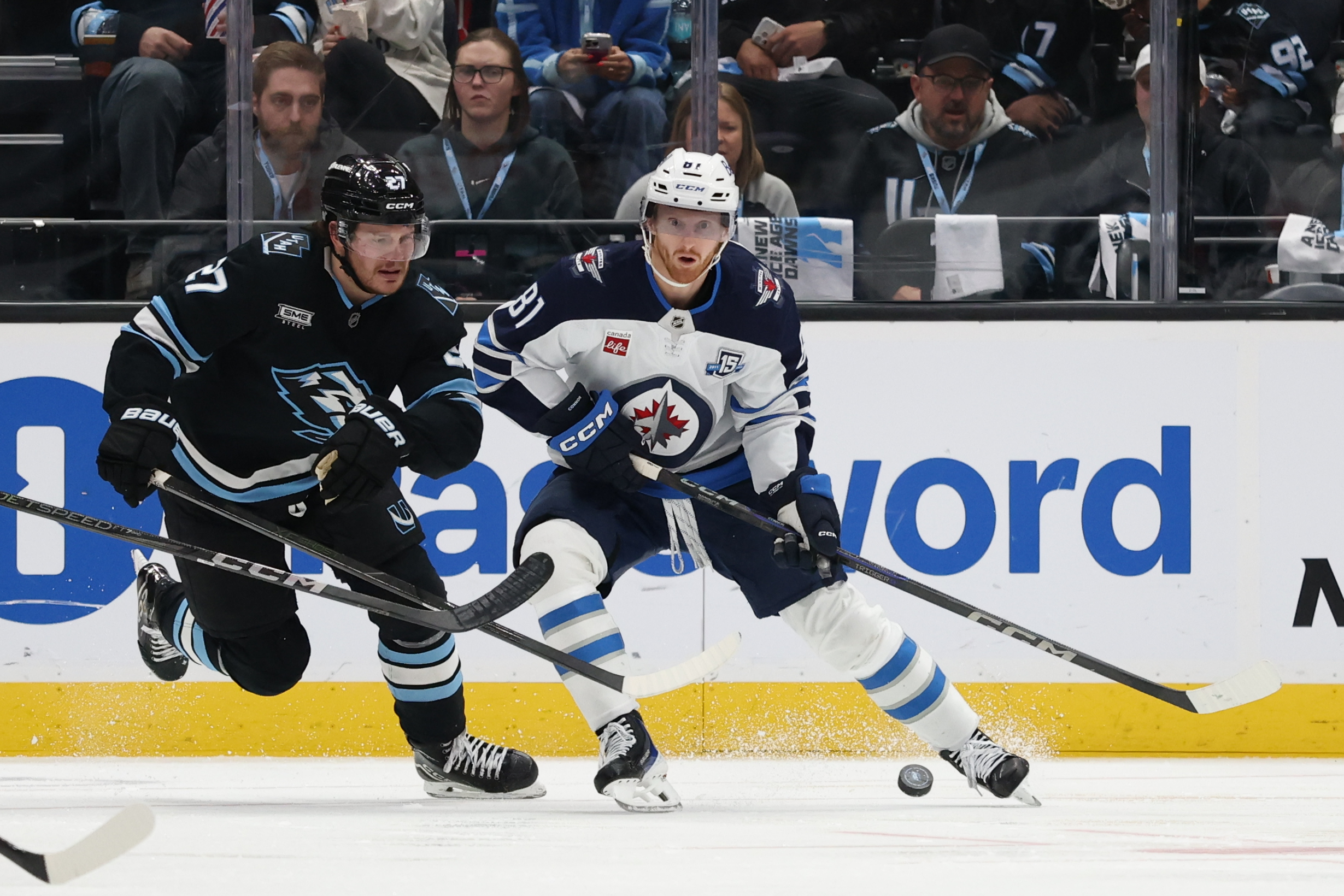 Dec 21, 2025; Salt Lake City, Utah, USA; Utah Mammoth center Barrett Hayton (27) and Winnipeg Jets left wing Kyle Connor (81) play for the puck during the third period at Delta Center. Mandatory Credit: Rob Gray-Imagn Images
