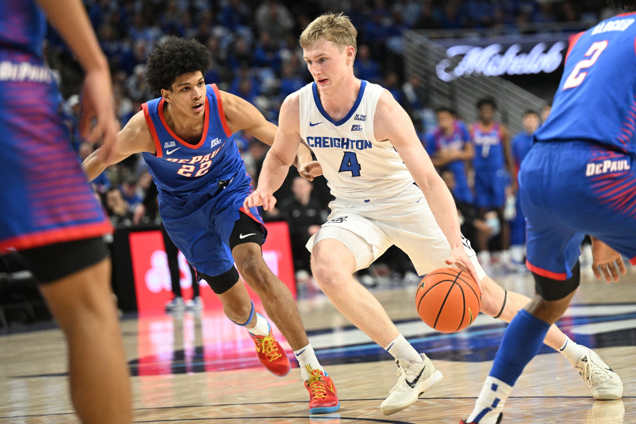 Feb 25, 2026; Omaha, Nebraska, USA;  Creighton Bluejays guard Josh Dix (4) drives against DePaul Blue Demons guard Kruz McClure (22) during the second half at CHI Health Center Omaha. Mandatory Credit: Steven Branscombe-Imagn Images