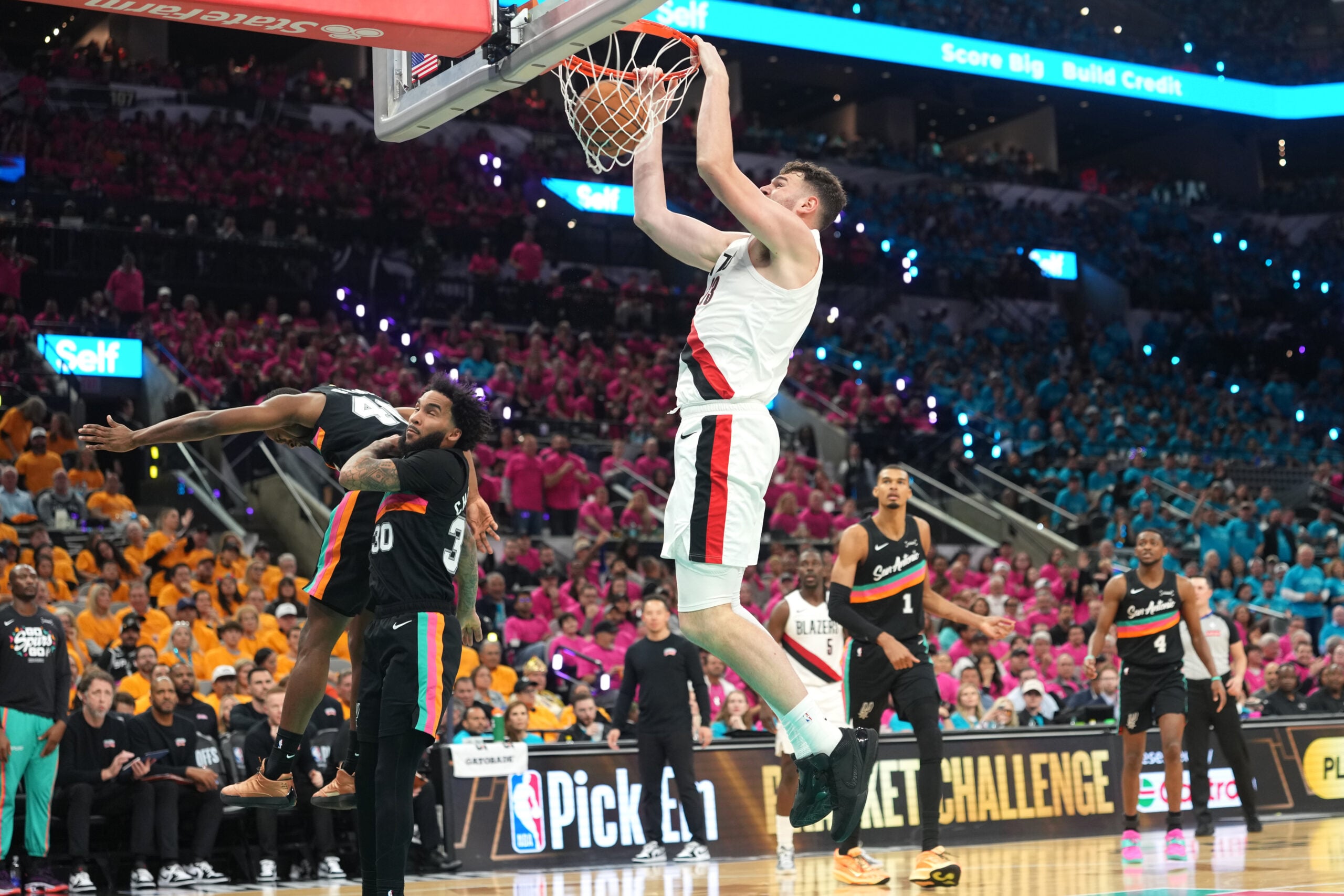 Apr 19, 2026; San Antonio, Texas, USA; Portland Trail Blazers center Donovan Clingan (23) dunks over San Antonio Spurs forward Julian Champagnie (30) during the second half of game one of the first round of the 2026 NBA Playoffs at Frost Bank Center. Mandatory Credit: Scott Wachter-Imagn Images