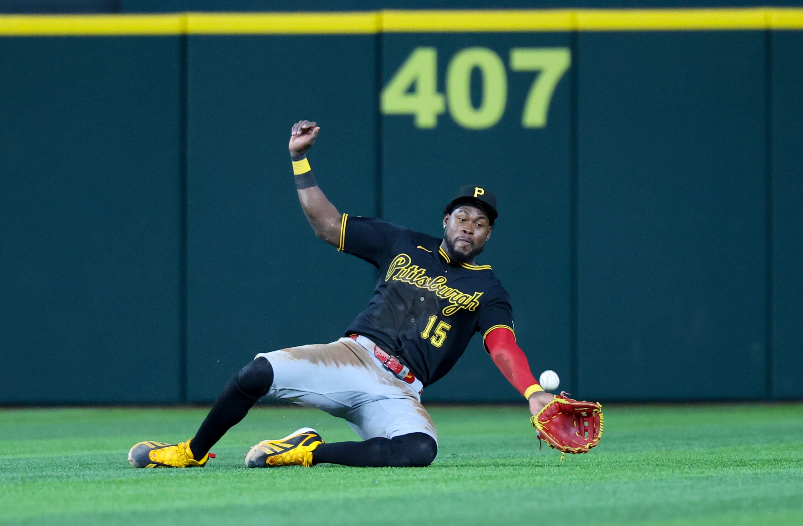 Apr 22, 2026; Arlington, Texas, USA;  Pittsburgh Pirates center fielder Oneil Cruz (15) dives but cannot make a catch during the seventh inning against the Texas Rangers at Globe Life Field. Mandatory Credit: Kevin Jairaj-Imagn Images