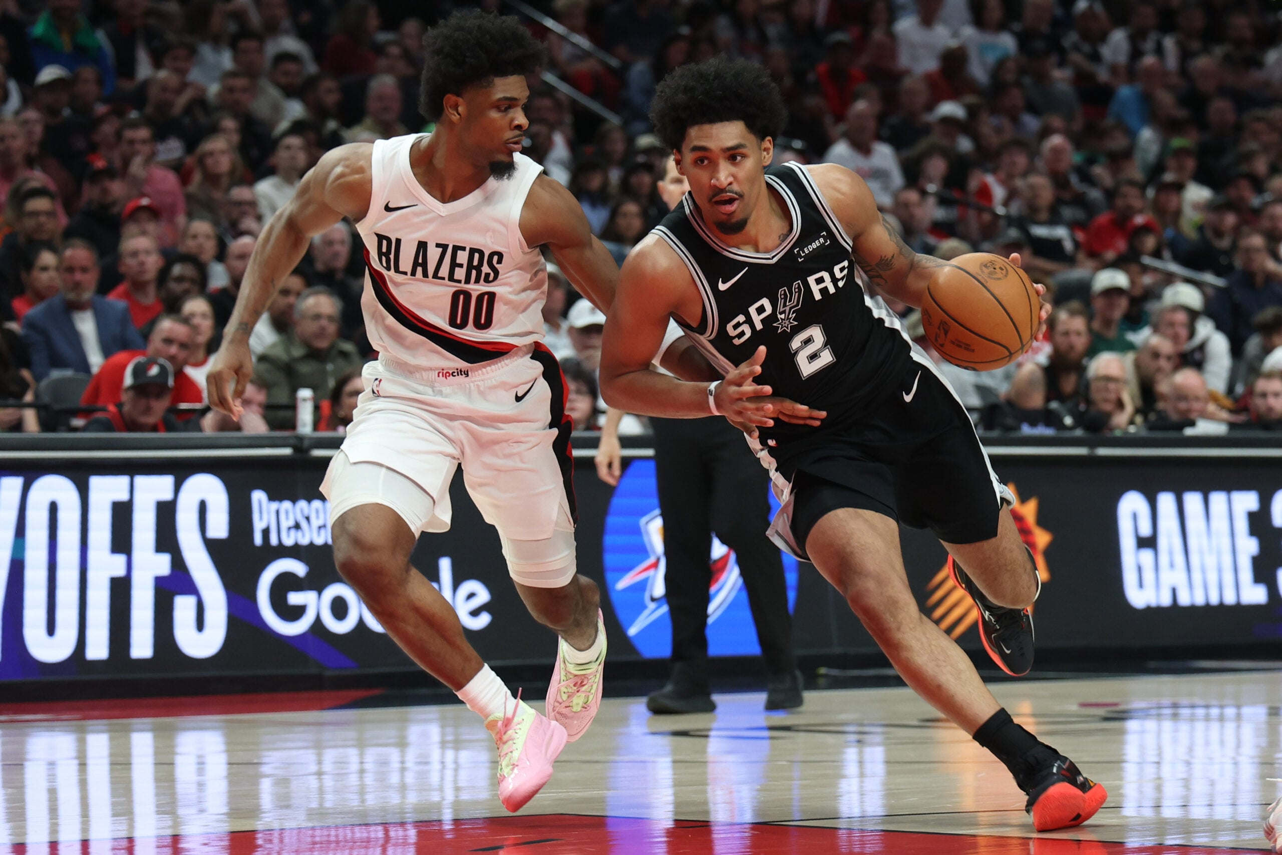 Apr 24, 2026; Portland, Oregon, USA; San Antonio Spurs guard Dylan Harper (2) drives to the basket past Portland Trail Blazers guard Scoot Henderson (00) during the second half during game three of the first round of the 2026 NBA Playoffs at Moda Center. Mandatory Credit: Jaime Valdez-Imagn Images