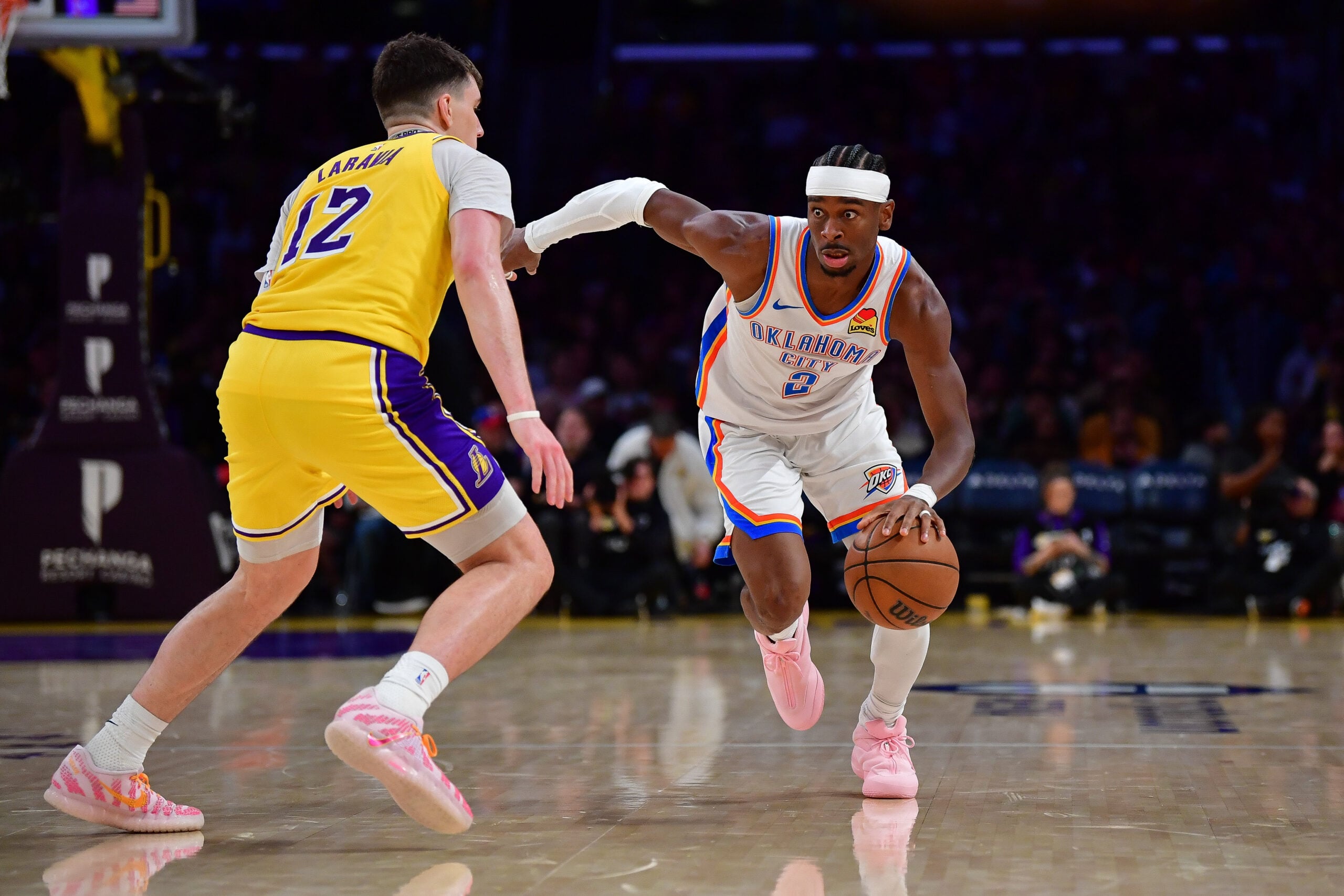 April 7, 2026; Los Angeles, California, USA; Oklahoma City Thunder guard Shai Gilgeous-Alexander (2) moves the ball against Los Angeles Lakers forward Jake LaRavia (12) during the second half at Crypto.com Arena. Mandatory Credit: Gary A. Vasquez-Imagn Images