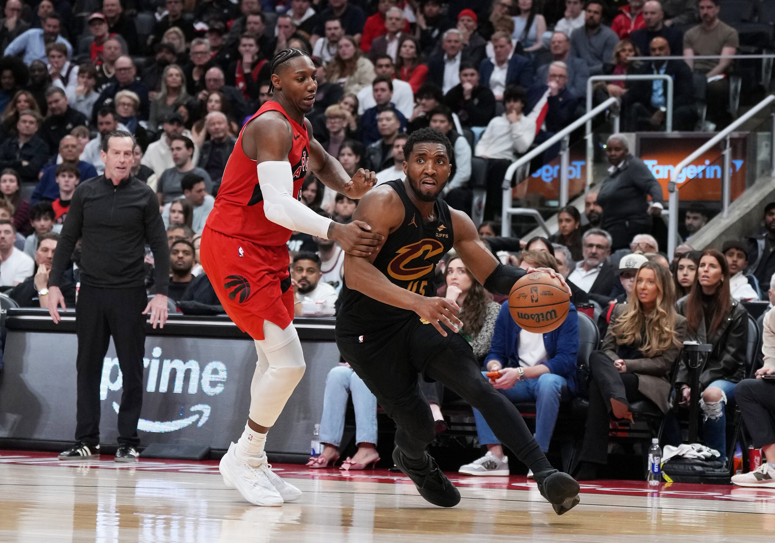 May 1, 2026; Toronto, Ontario, CAN; Cleveland Cavaliers guard Donovan Mitchell (45) controls the ball as Toronto Raptors forward RJ Barrett (9) tries to defend during the overtime period in game six of the first round of the 2026 NBA Playoffs at Scotiabank Arena. Mandatory Credit: Nick Turchiaro-Imagn Images